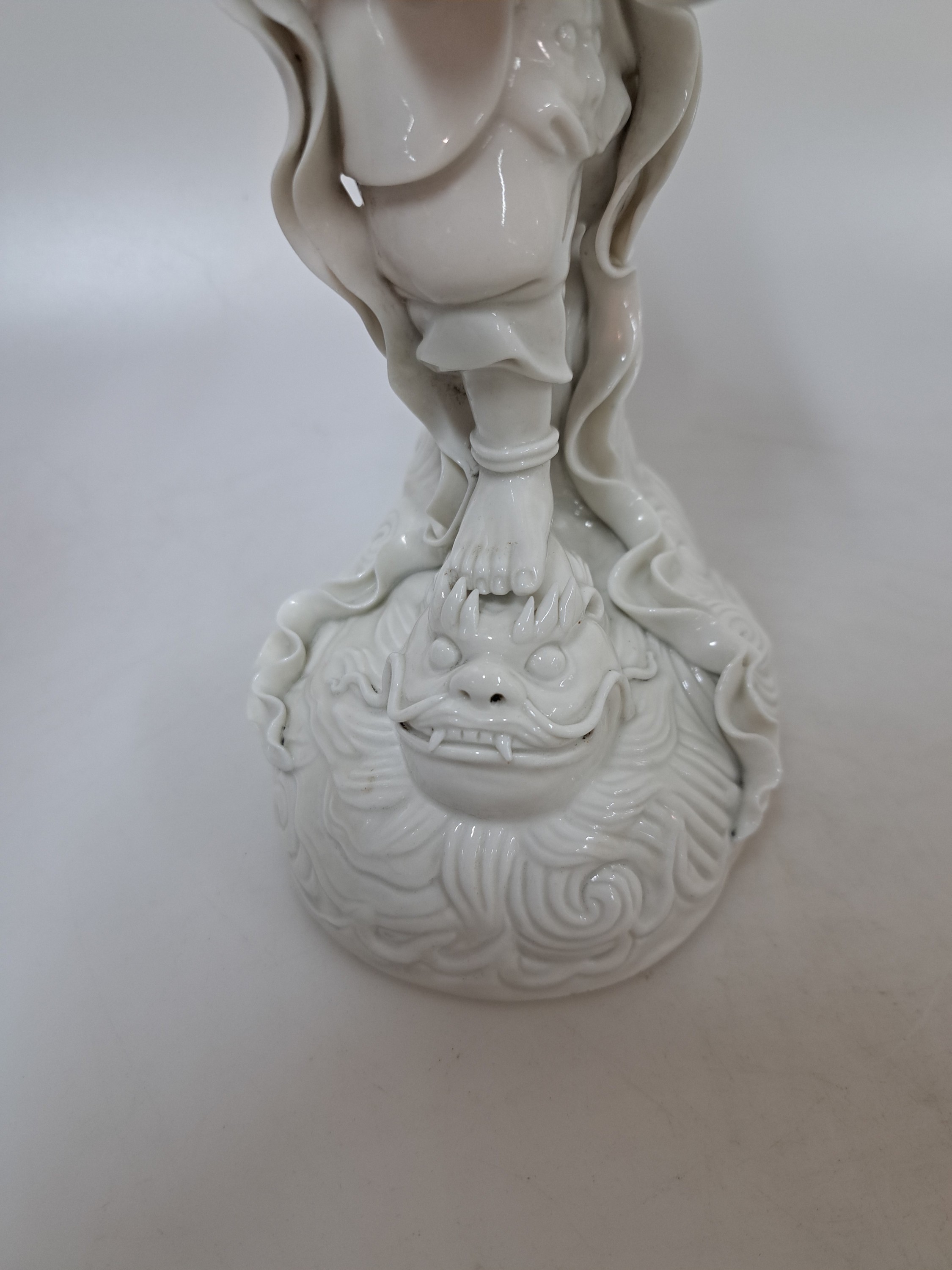 Detail e: Porzellanfigur, China, um 1900, sog. blanc-de-blanc, Darstellung eines Dämon, auf einem Drachenkopf stehend, H. ca. 27cm