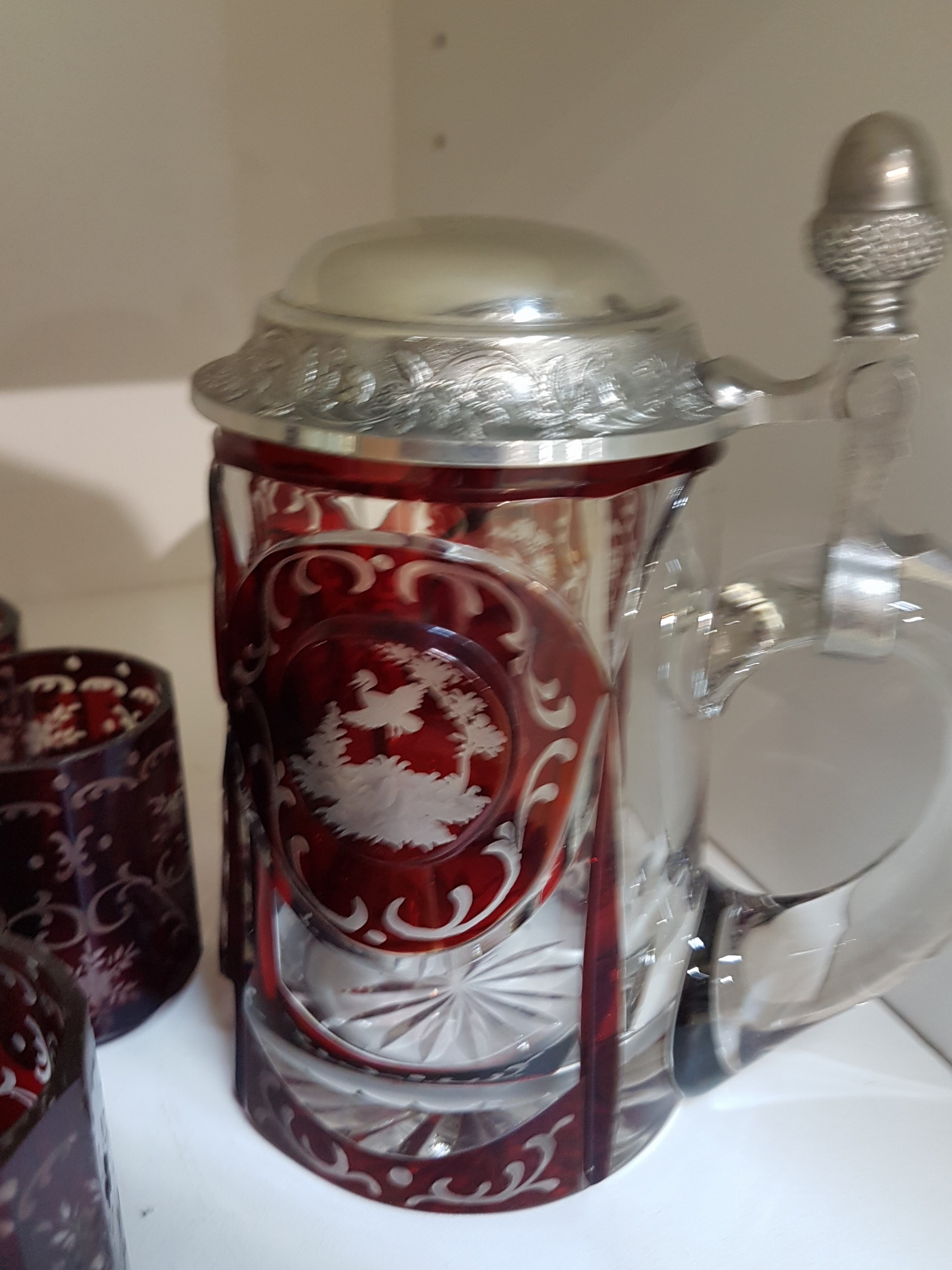 Detail c: Historismus Glasset, böhmisch, 19./20.Jh., farbloses Glas, rubiniert, floral-ornamentaler Dekor, Flasche (Stöpsel fehlt), 16 Gläser in z.T. leicht ...