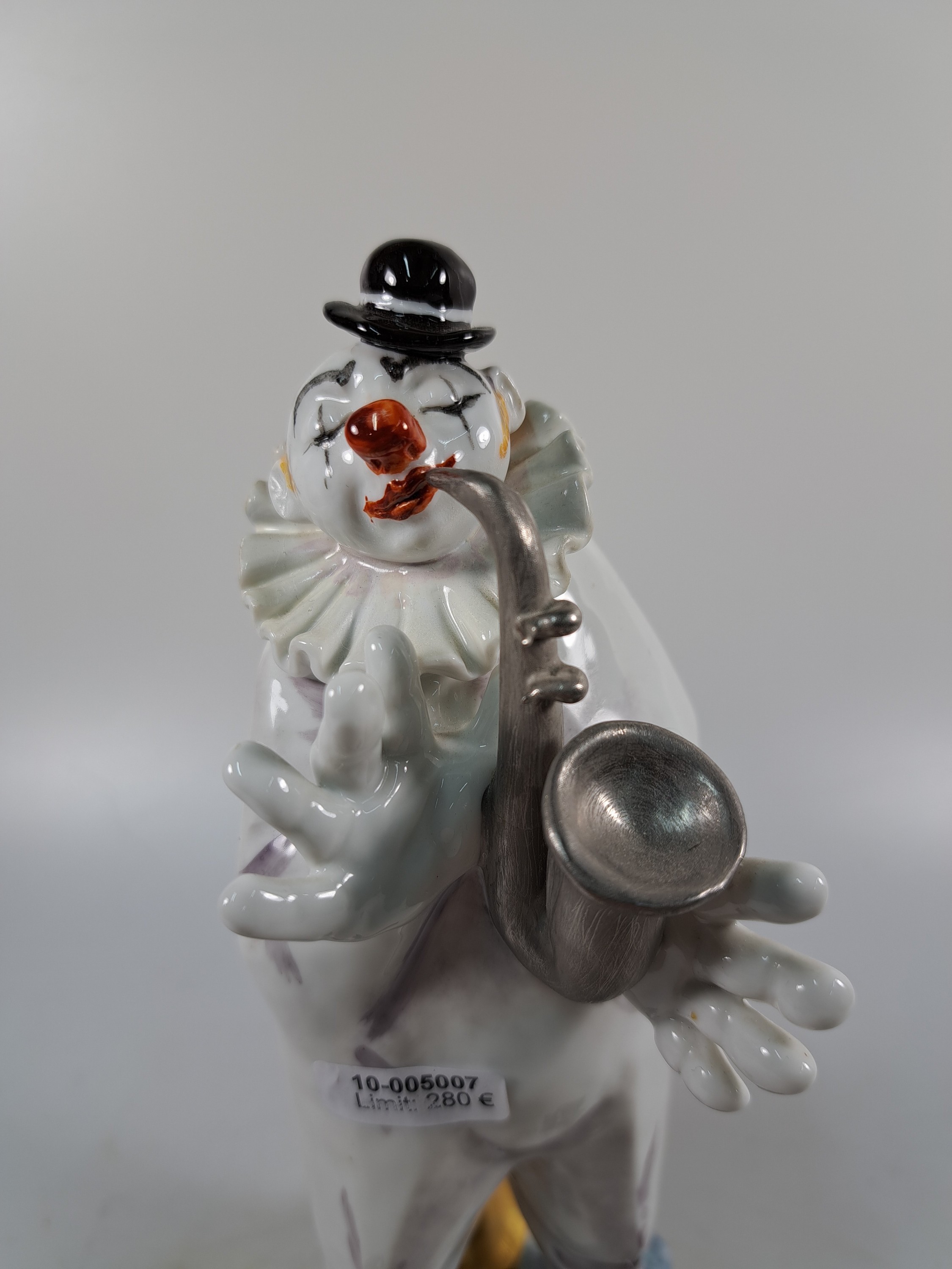 Detail b: Porzellanfigur aus der Clownskapelle, Entwurf Peter Strang Meissen, 20. Jh., Saxophonspieler, polychrom bemalt, ca. 21 x 10x 7.5 cm, num. 60462, rest.