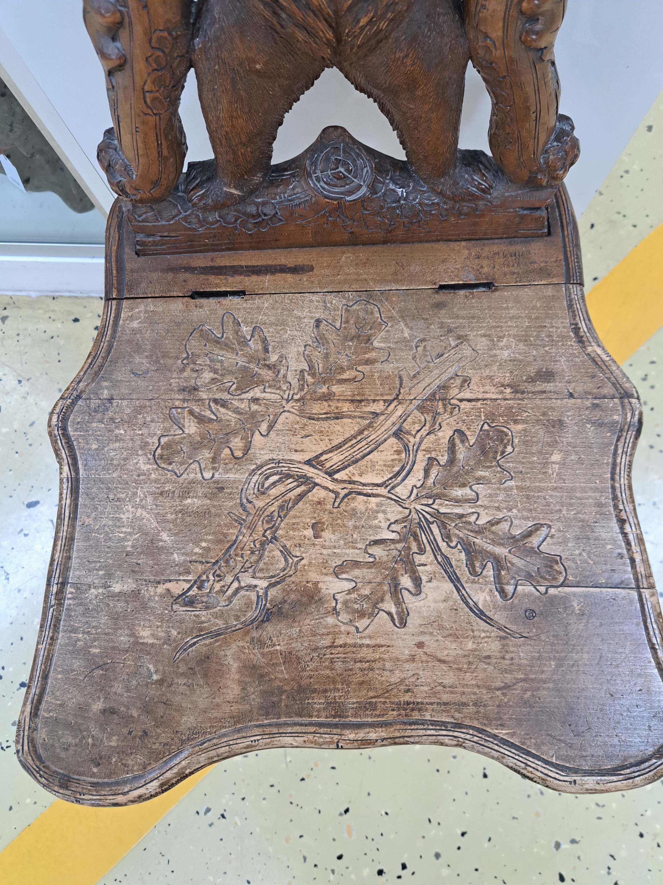 Detail b: sog. Bärenstuhl, wohl Brienz, Schweiz, um 1880/90, Holz geschnitzt, Rücklehne mit stehendem Bären von Eichenstämmen mit Blättern eingerahmt, ...