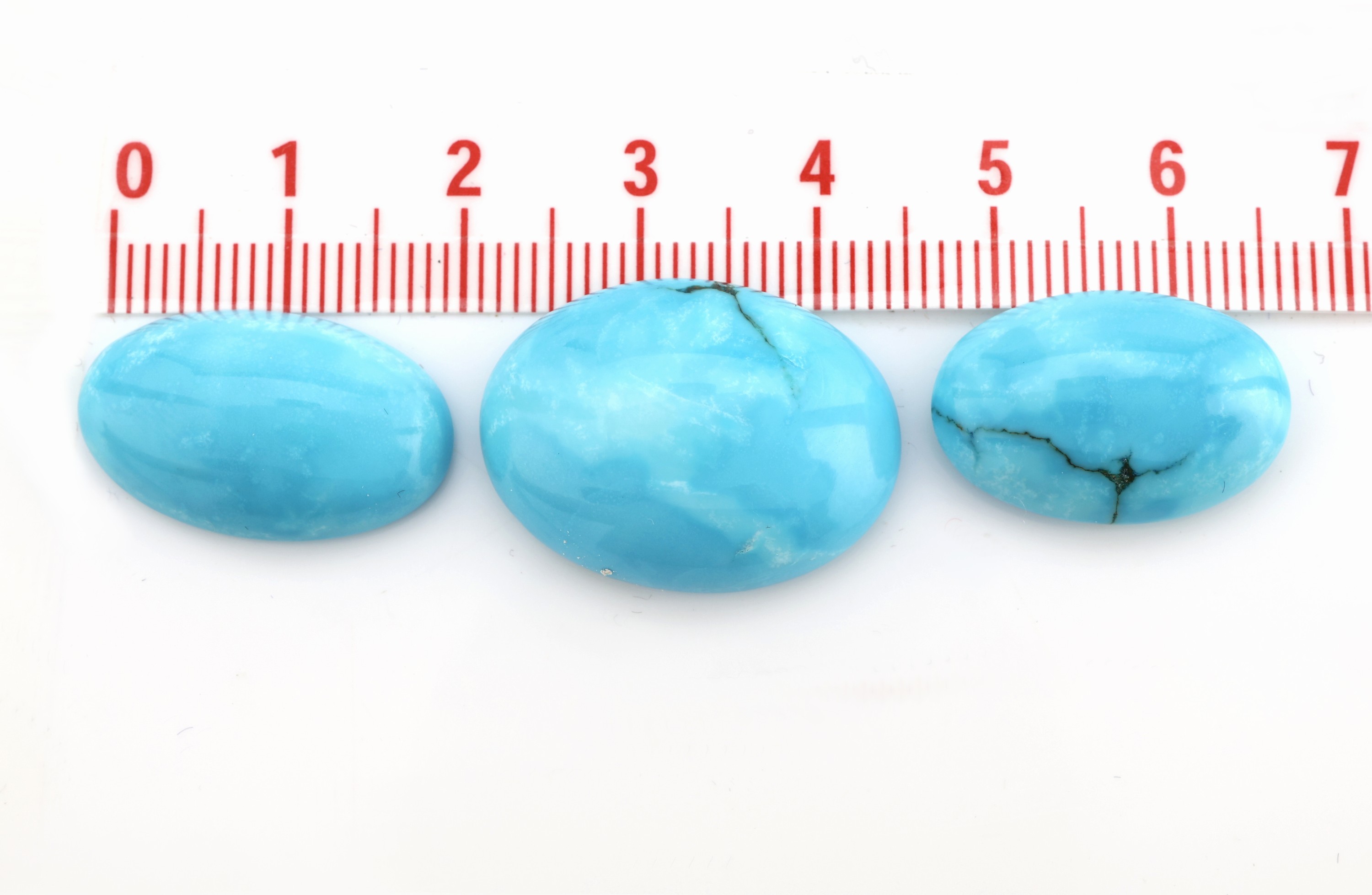 Detail b: 3 lose Türkiscabochons, ca. 46.87 ct, oval, inversch. Größen