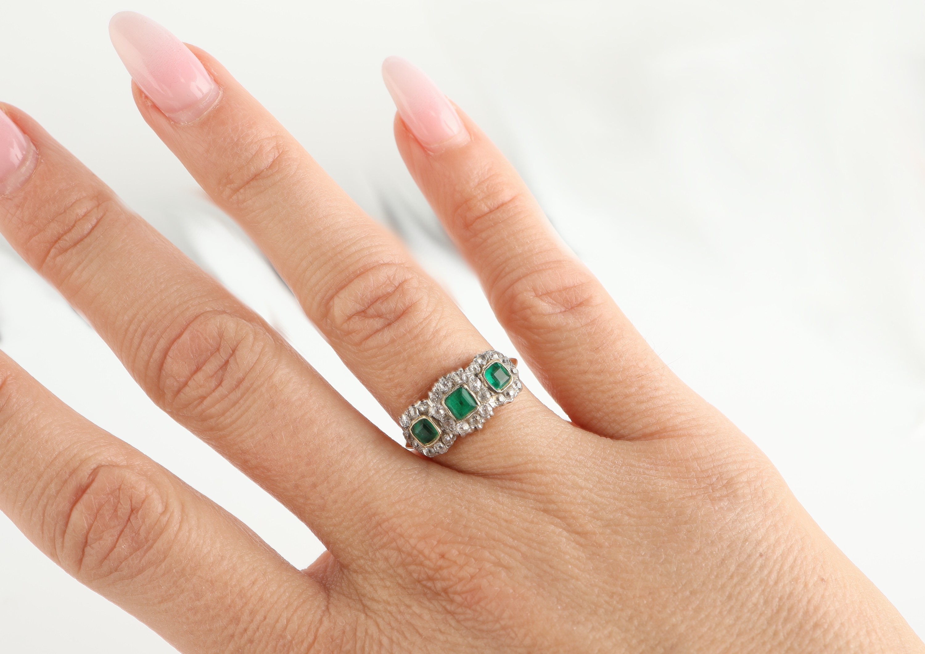 Detail e: 18 kt Gold Smaragd-Diamant-Ring, um 1900-10, GG 750/000, 3 facett. Smaragd-Carrees zus. ca. 0.60 ct, 26 in Silber gefasste Altschliffdiamanten zus. ...