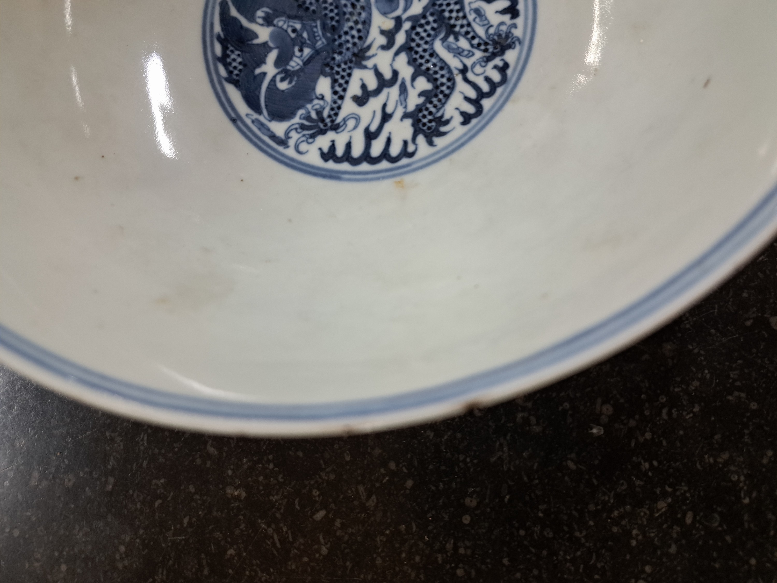 Detail c: Schale, China, nach Kang Xi-Vorbild, 19. Jh., blaue Unterglasurbemalung, Wandung mit zwei Drachen und Wolkenmotiv, mittig innen auch ...