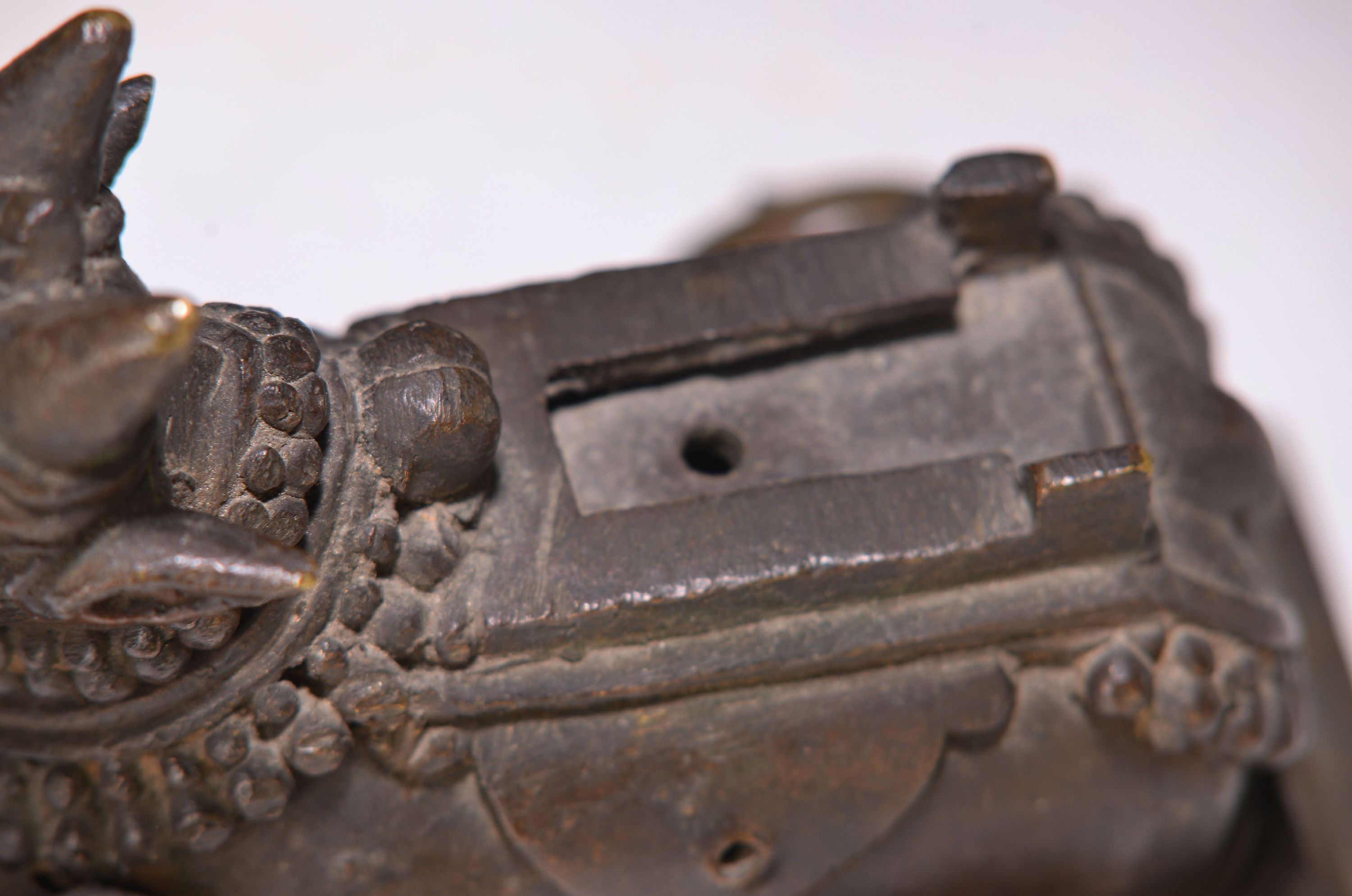 Detail b: Buddhamaske und vier Bronzestücke, Indien, 18.-19. Jh., Heilige Kuh Kamadhenu auf Rollen, oben mit Bohrung, zwei versch. Öllampen, Messingschüssel ...