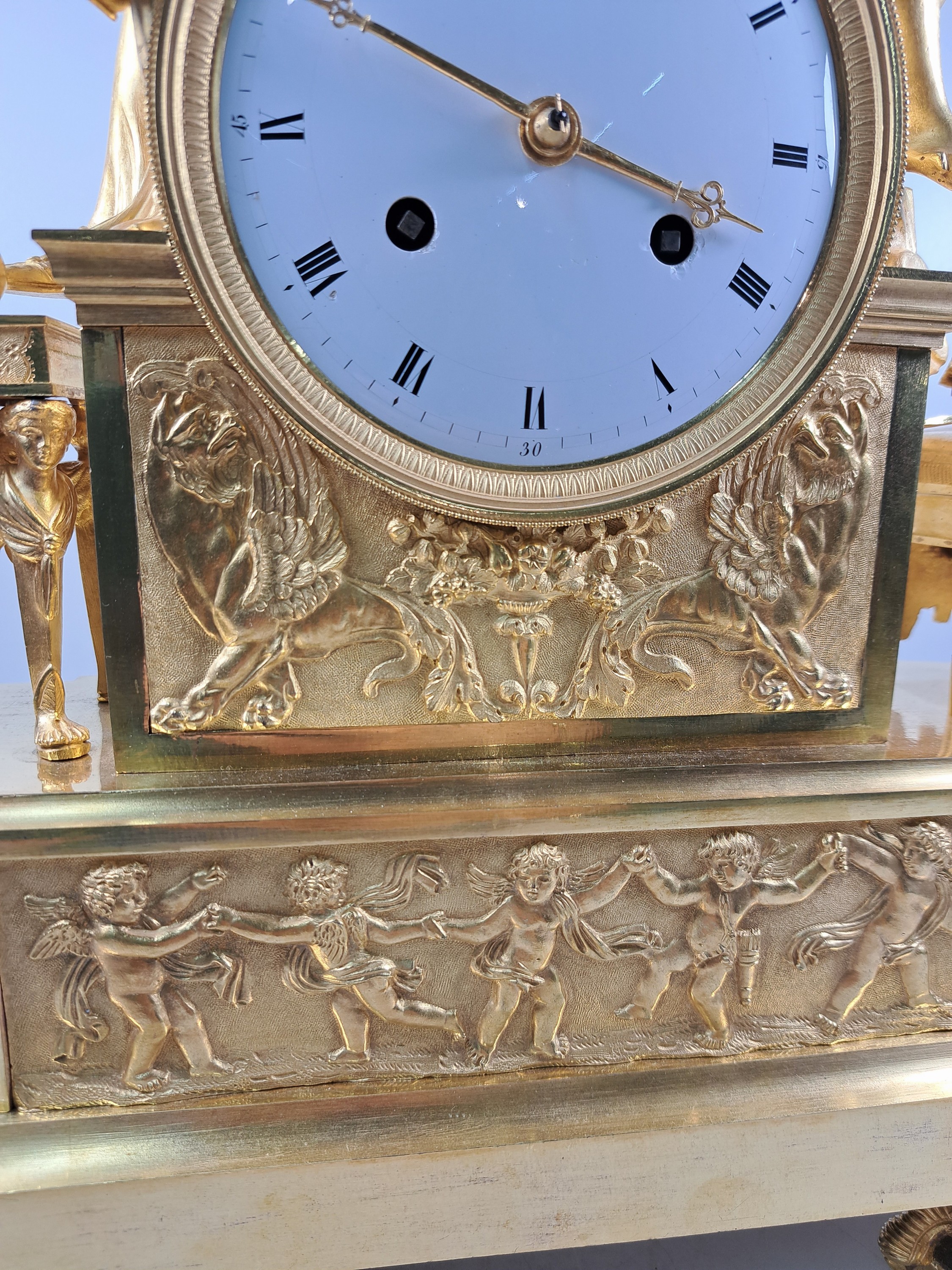 Detail d: Pendule, Frankreich, um 1810-20, Bronze matt- und glanzvergoldet, im Sockel tanzende Putti, neben Uhr Tabouret darauf Pfeilköcher mit Bogen, ...