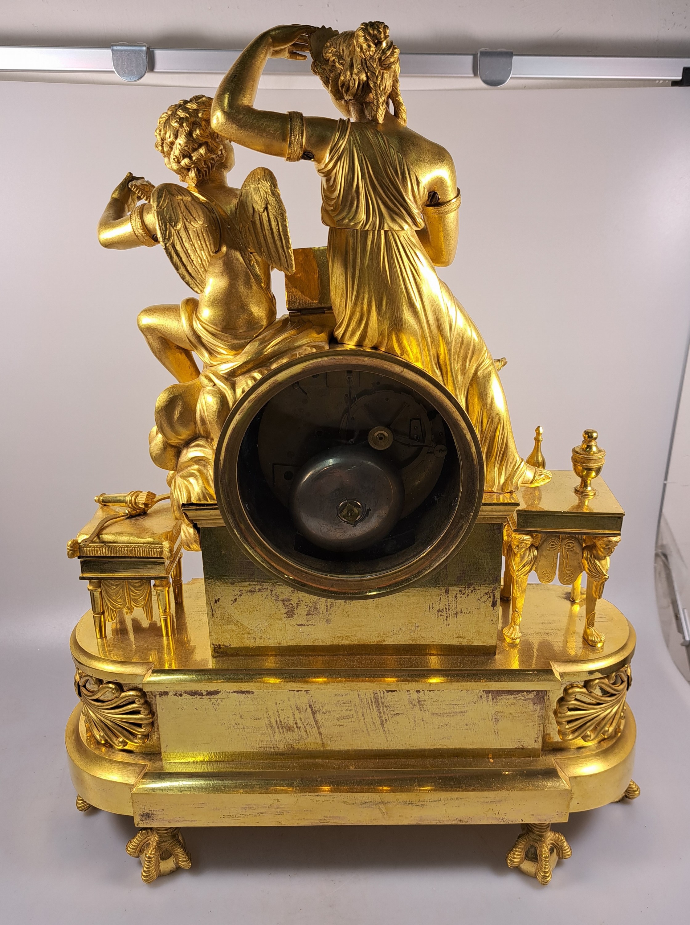 Detail e: Pendule, Frankreich, um 1810-20, Bronze matt- und glanzvergoldet, im Sockel tanzende Putti, neben Uhr Tabouret darauf Pfeilköcher mit Bogen, ...