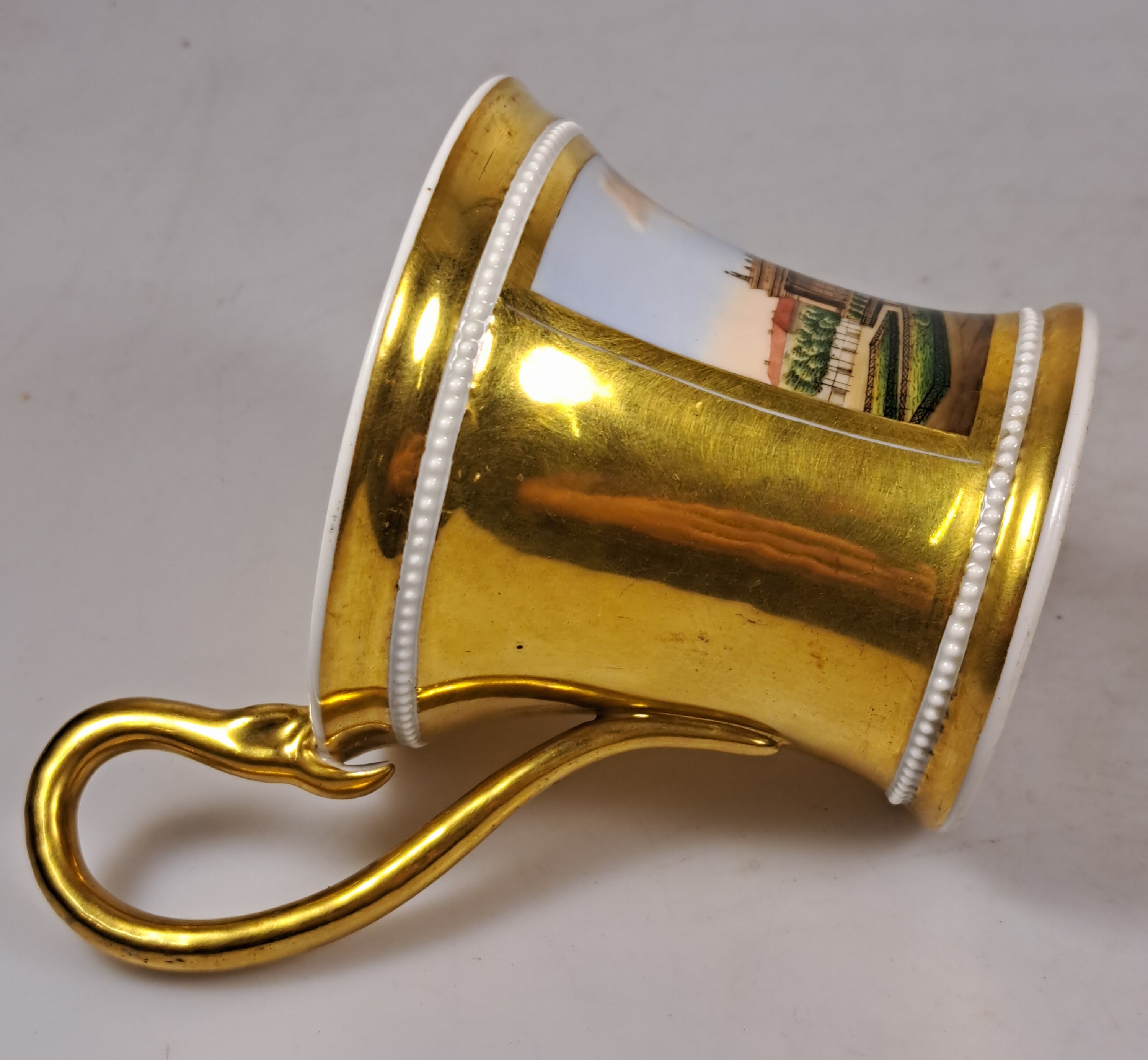 Detail k: Tasse mit Untertasse, KPM Berlin, um 1820, Porzellan, reich glanzvergoldet, in Kartusche feine bunte Malerei des Museums in Berlin mit ...