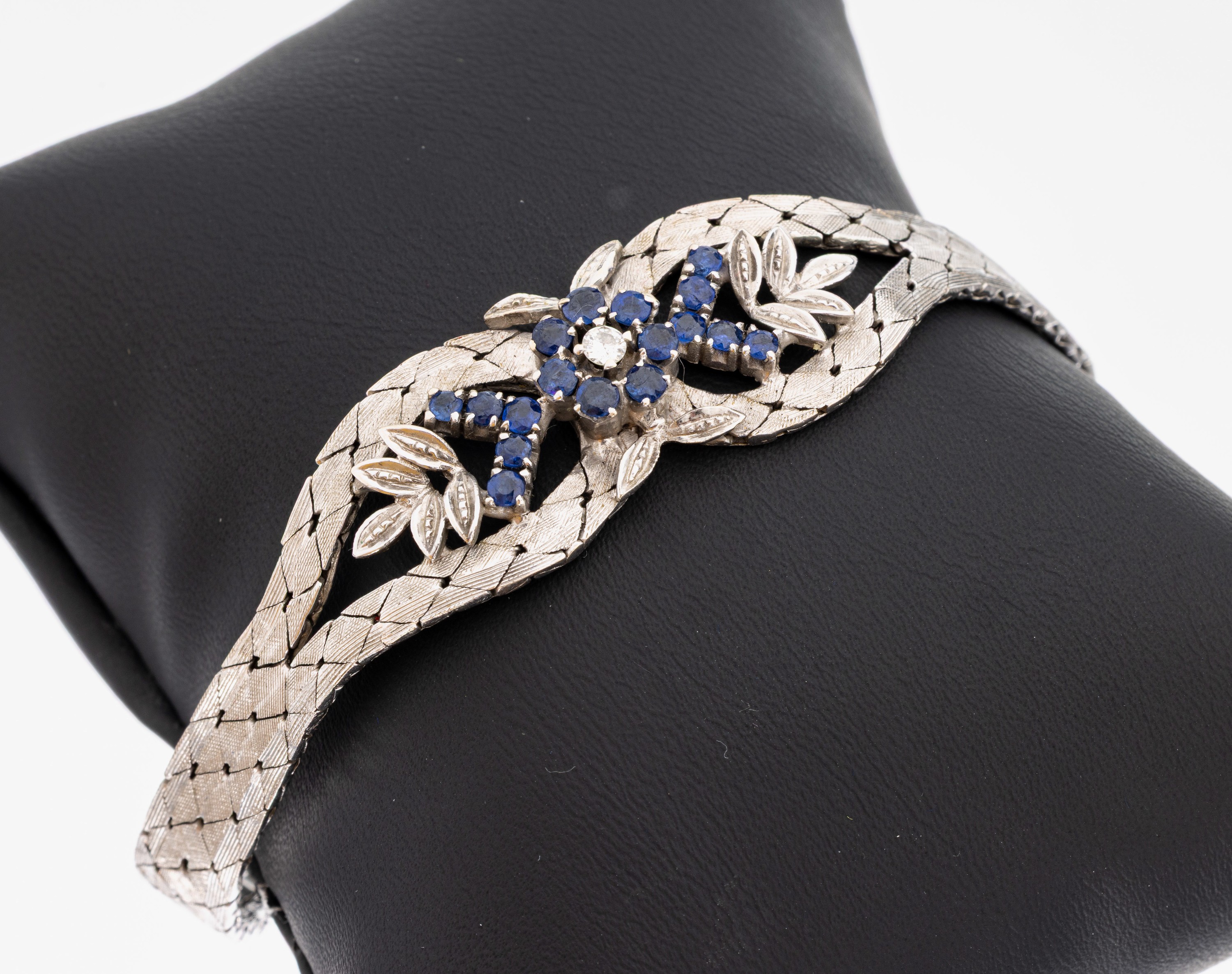 14 kt Gold Saphir-Brillant-Armband, 1970er Jahre, WG 585/000 sat., florales Mittelteil, 17 rundfacett. Saphire zus. ca. 1.10 ct, 1 Brillant ca. 0.07 ...