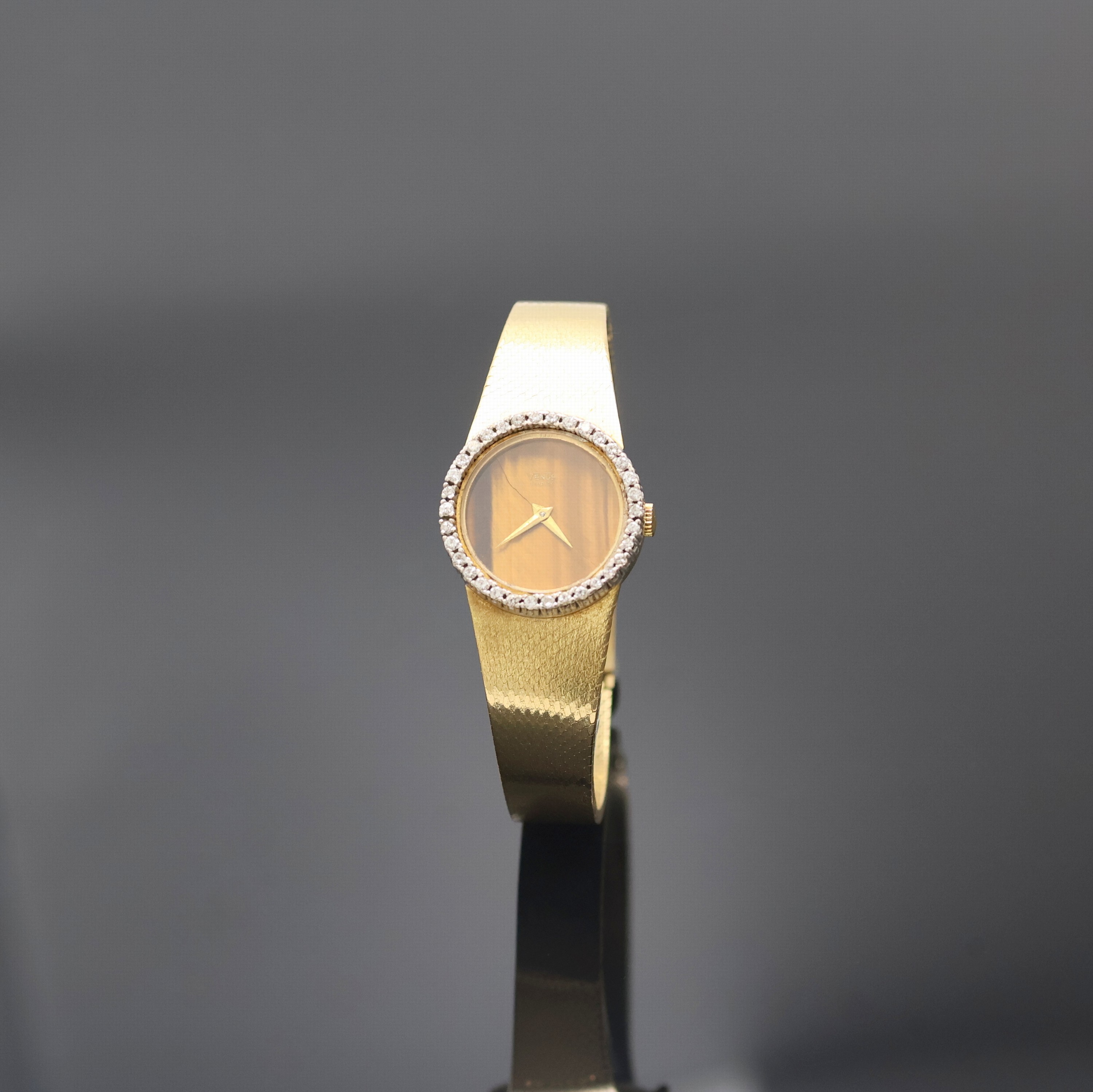 VENUS Damenarmbanduhr in GG 750/000 mit Diamantlünette, Schweiz um 1965, Handaufzug, Goldband, Boden aufgedr., Tigeraugen- Zifferbl. geriss./besch., ...