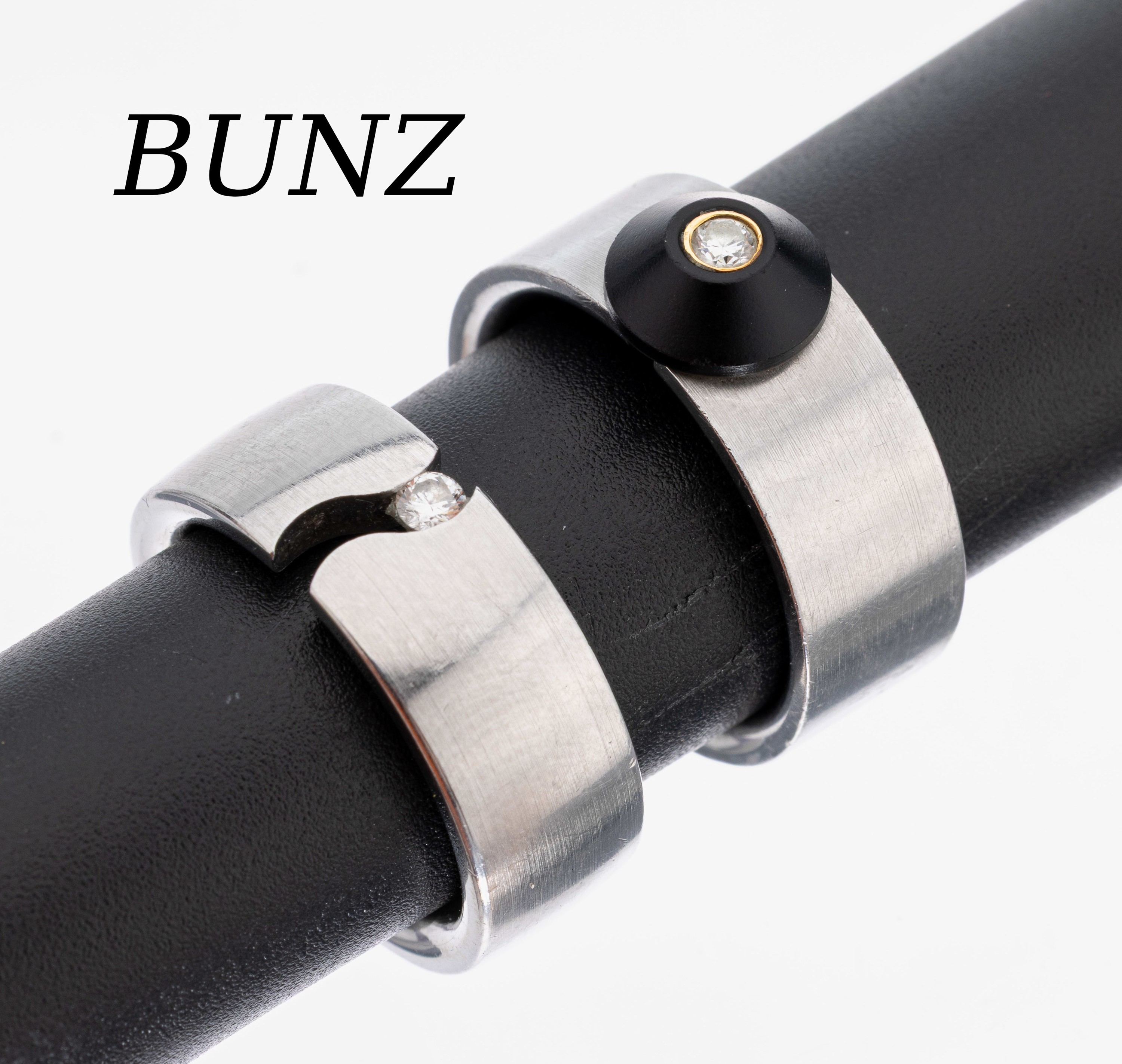 Konvolut 2 BUNZ Brillant-Ringe, Stahl und GG 750/000, 1 x Spannring mit kl. Brillant, 1 x mit Onyx-Trapez mit kl. Brillant in GG gefasst, zus. ca. ...