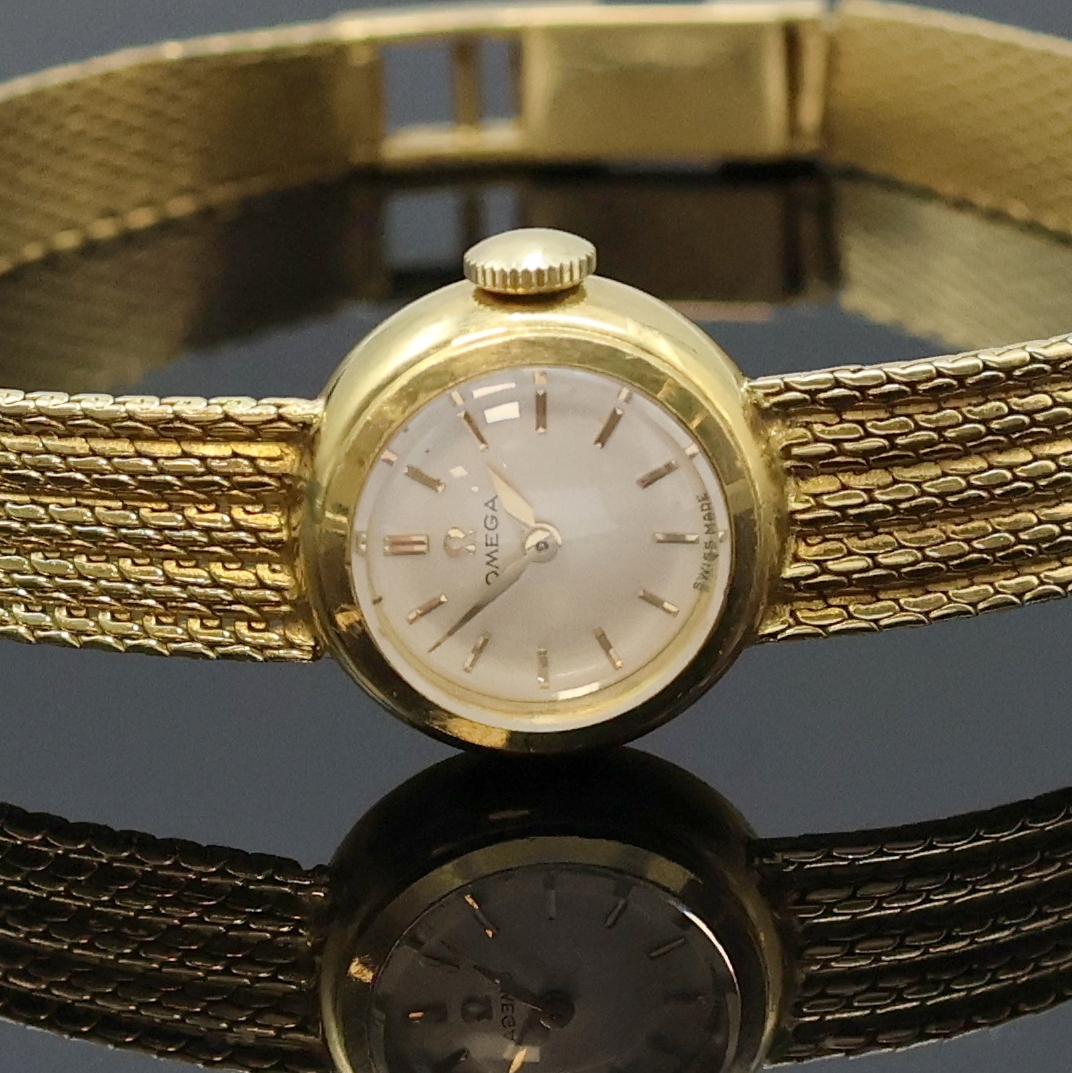Detail a: OMEGA Damenarmbanduhr in GG 750/000, Schweiz um 1960, Handaufzug, orig. Goldband, Boden aufgedr., silb. Zifferbl. m. gold. Std.-Ind. u. Zeigern, ...