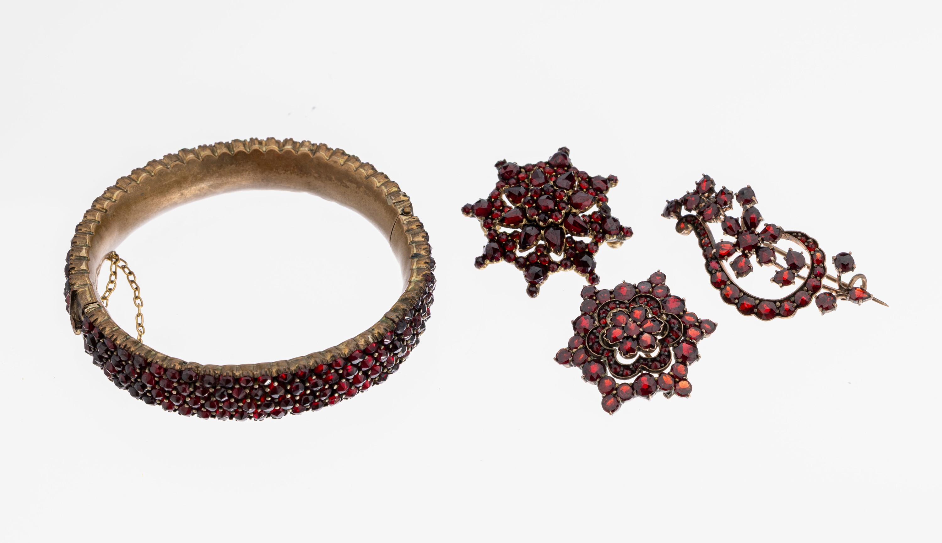 Konvolut Granatschmuck, Böhmen um 1890, Tombak, best. aus: 3 Broschen, 1 Armreif, facett. Granate von schöner Farbe, Armreifd. ca. 5.6 x 5 cm, ...