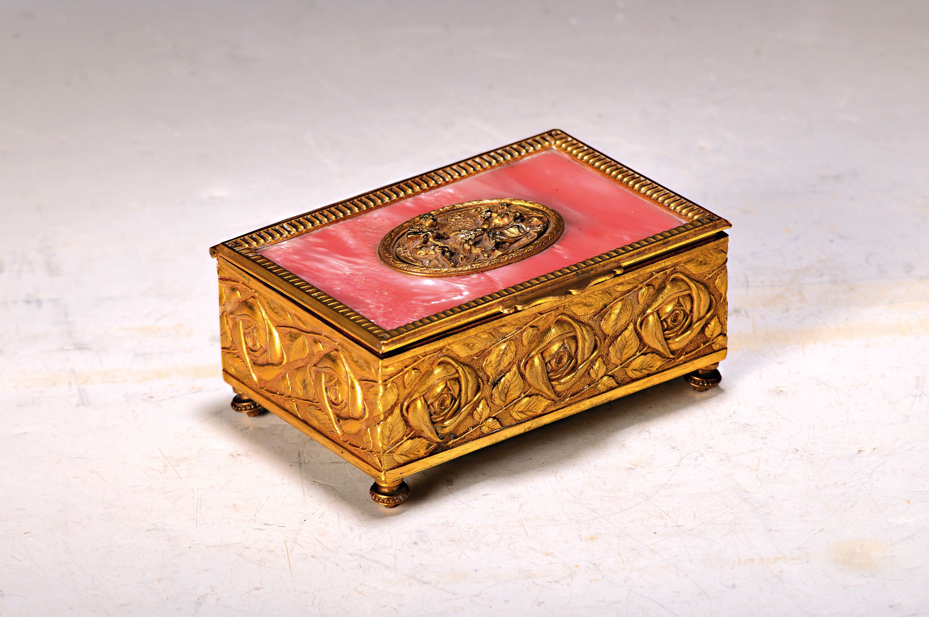 Spieluhr, um 1900/20, Messinggehäuse mit umlaufendem Rosendekor, im oval galante Szene, Perlmuttimitat, innen mit Holz ausgeschlagen, ca. 5 x 12.5 x ...