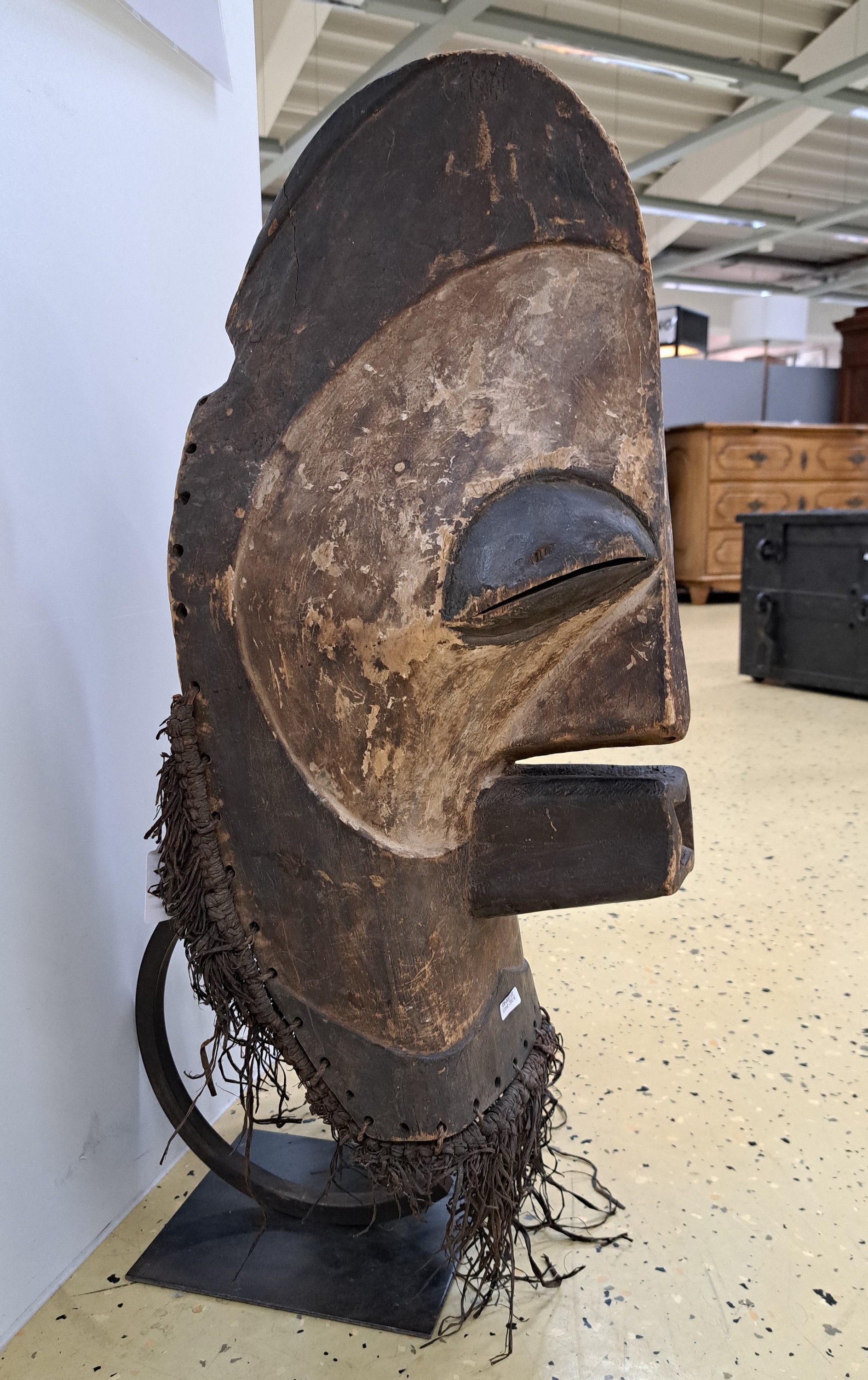 Detail b: Gesichtsmaske, Songye, DR Kongo, Mitte 20.Jh. , Holz geschnitzt, partielle Kaolinfassung, Raffiagewebe, H. 58 cm, auf Metallständer