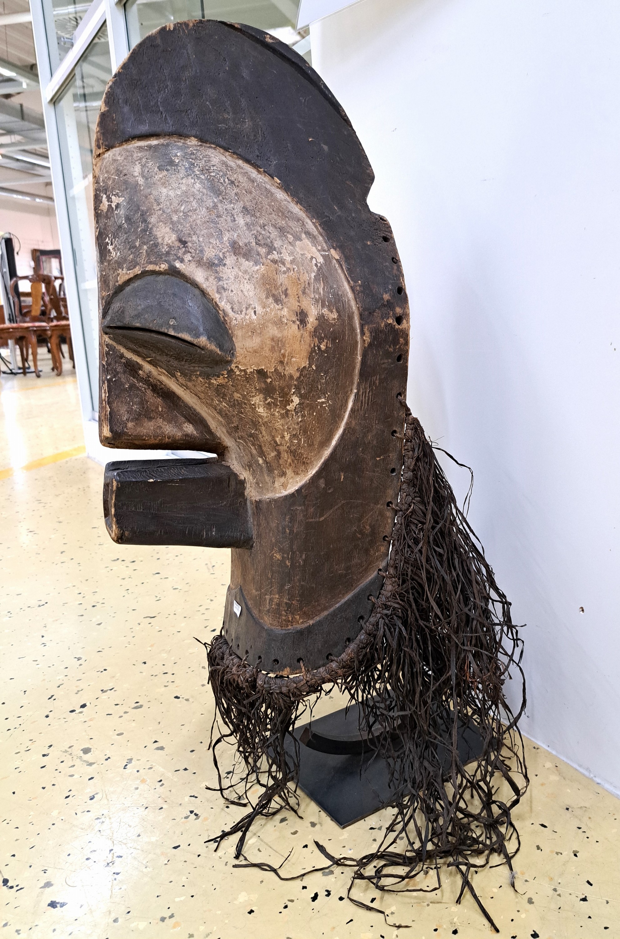 Detail c: Gesichtsmaske, Songye, DR Kongo, Mitte 20.Jh. , Holz geschnitzt, partielle Kaolinfassung, Raffiagewebe, H. 58 cm, auf Metallständer