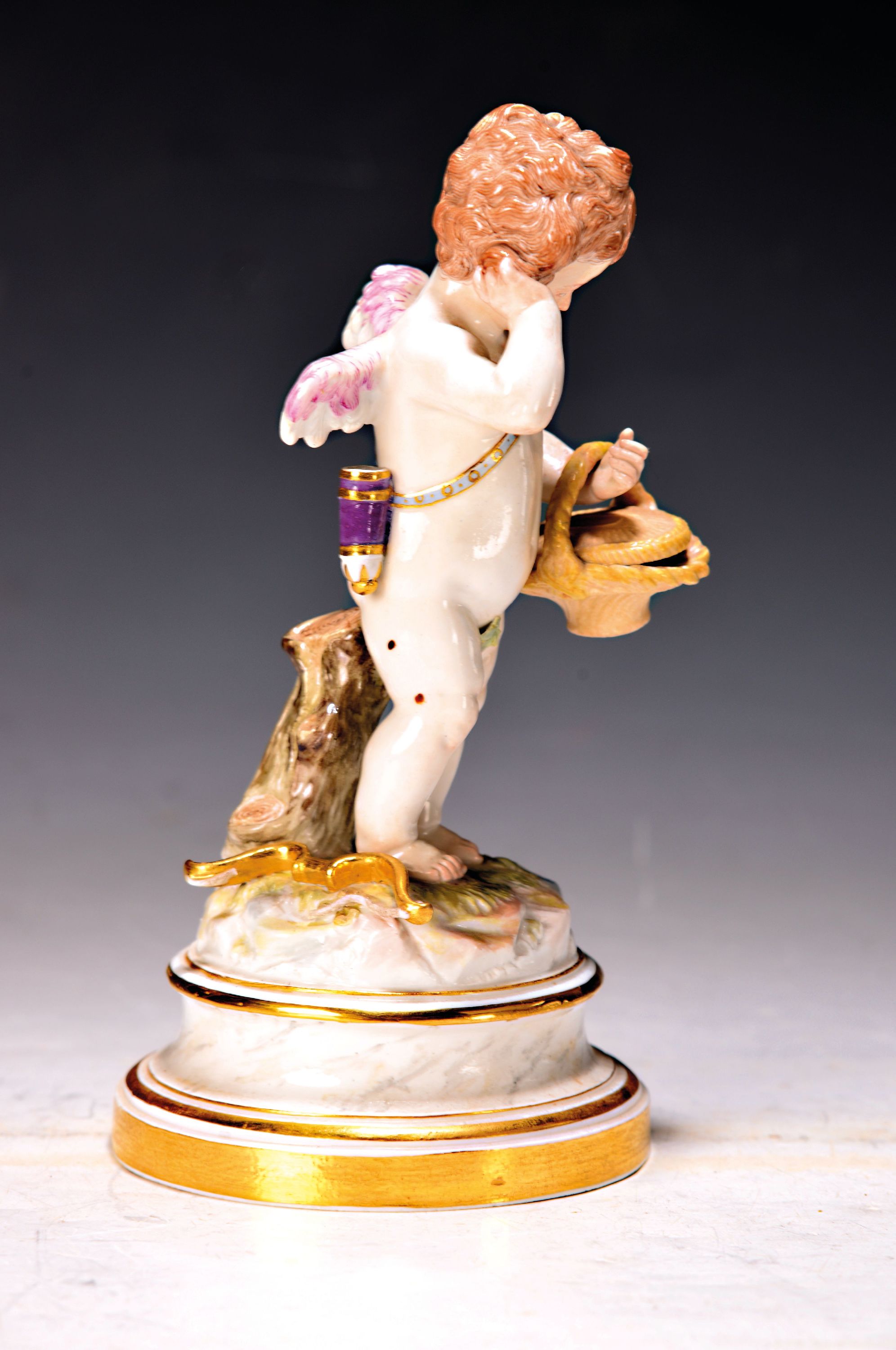 Detail a: Porzellanfigur, Meissen, um 1880/90, Entwurf Heinrich Schwabe, enttäuschter Amor mit Korb, Bogensehne gebrochen (vorhanden),polychrom bemalt, ...