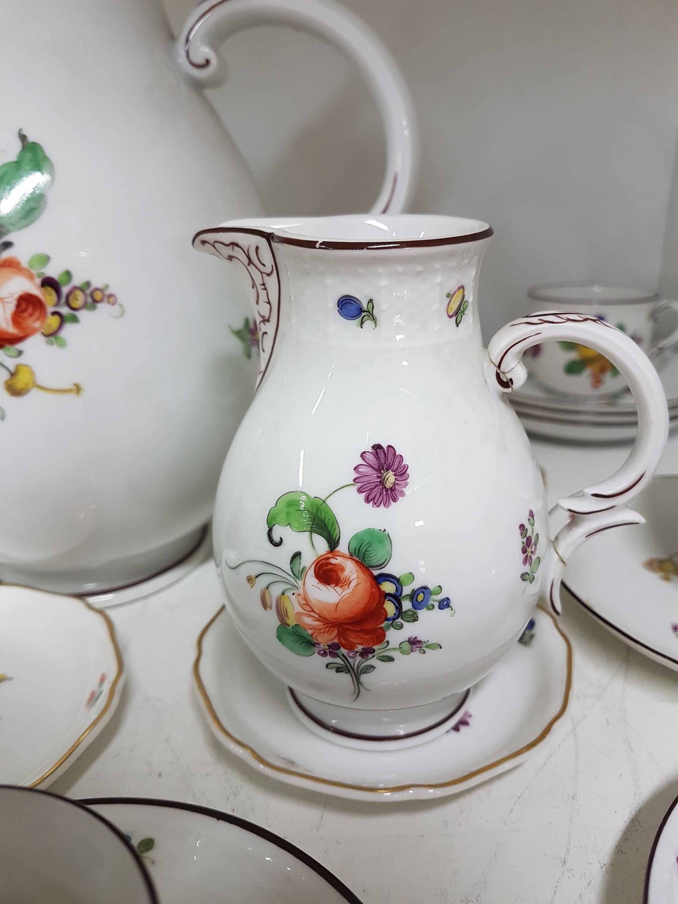 Detail d: Mokka- bzw. Espressoservice, Nymphenburg, um 1920, Porzellan, mit bunter Malerei von Blumenbuketts und gestreuten Blumen, brauner Rand, Kanne, ...