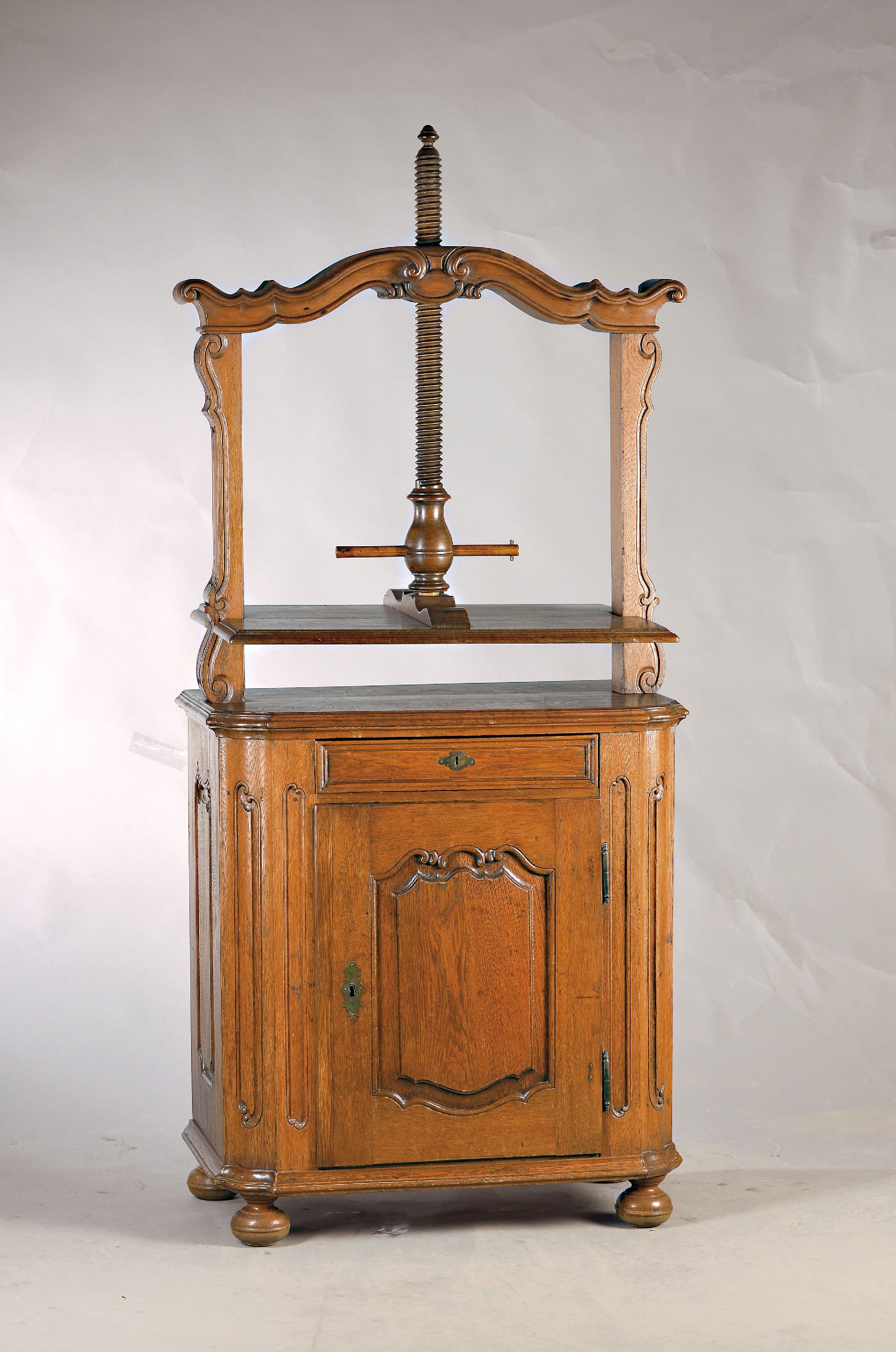 Kleiner Barockschrank mit Aufsatz, um 1760, Eiche massiv, eintüriger Korpus mit Schublade, Kanten geschweift, Türen und Seiten kassettiert und ...
