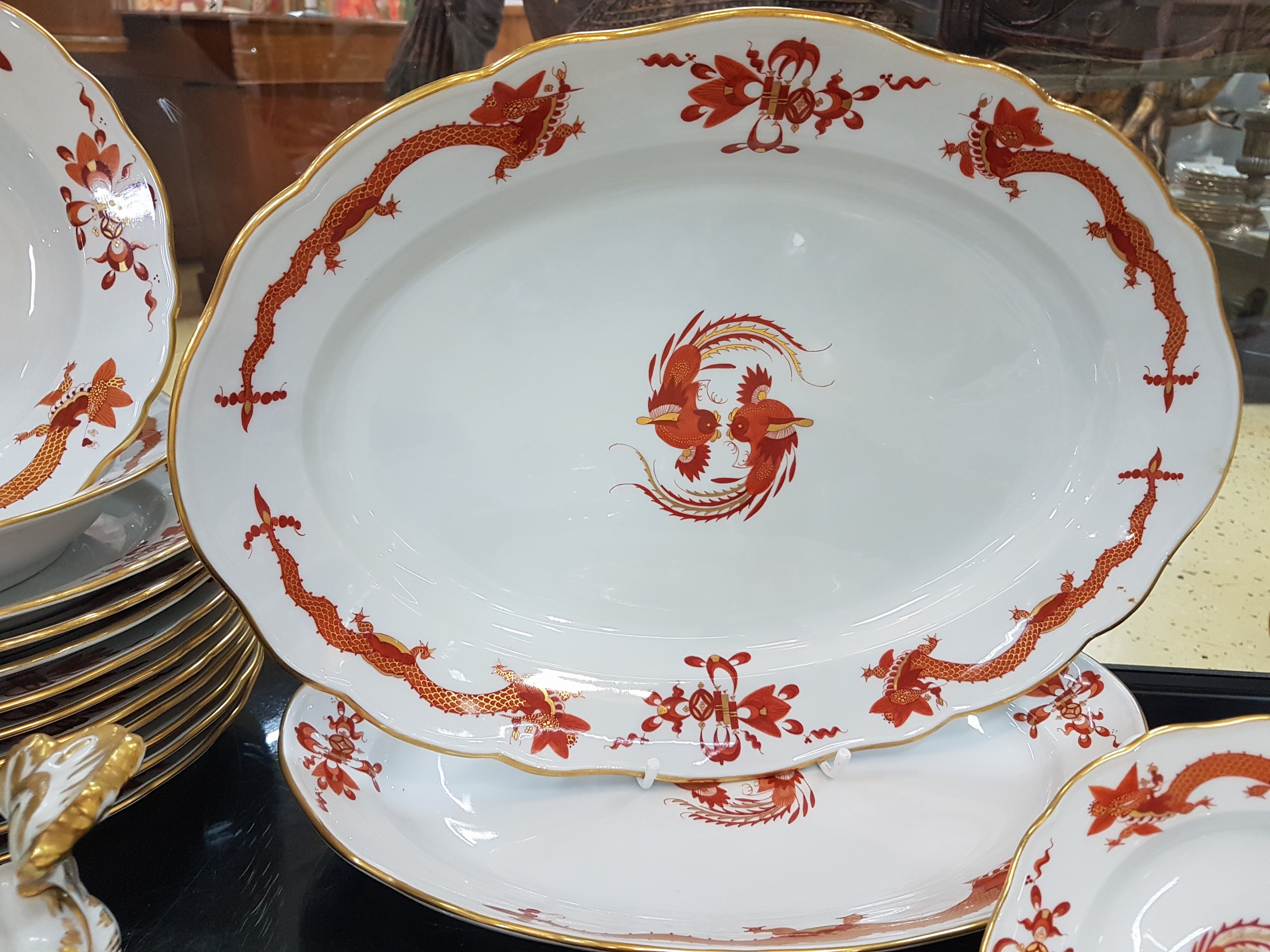Detail c: Speiseservice, Meissen, 20. Jh., 1. Wahl, Dekor roter Hofdrache goldschattiert, 11 flache Teller, 3 tiefe Teller (davon einer 2. Wahl), 6 ...