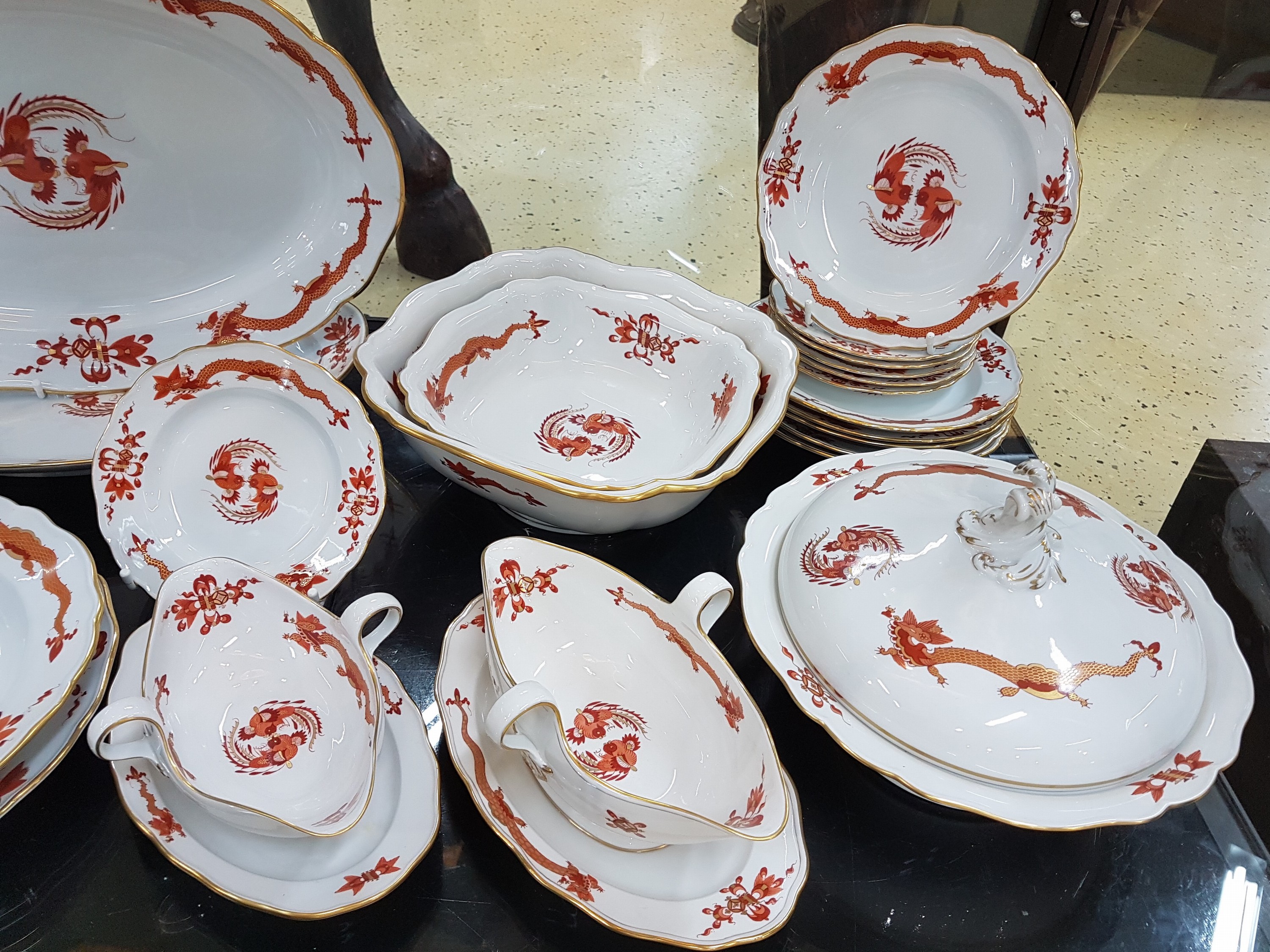 Detail d: Speiseservice, Meissen, 20. Jh., 1. Wahl, Dekor roter Hofdrache goldschattiert, 11 flache Teller, 3 tiefe Teller (davon einer 2. Wahl), 6 ...