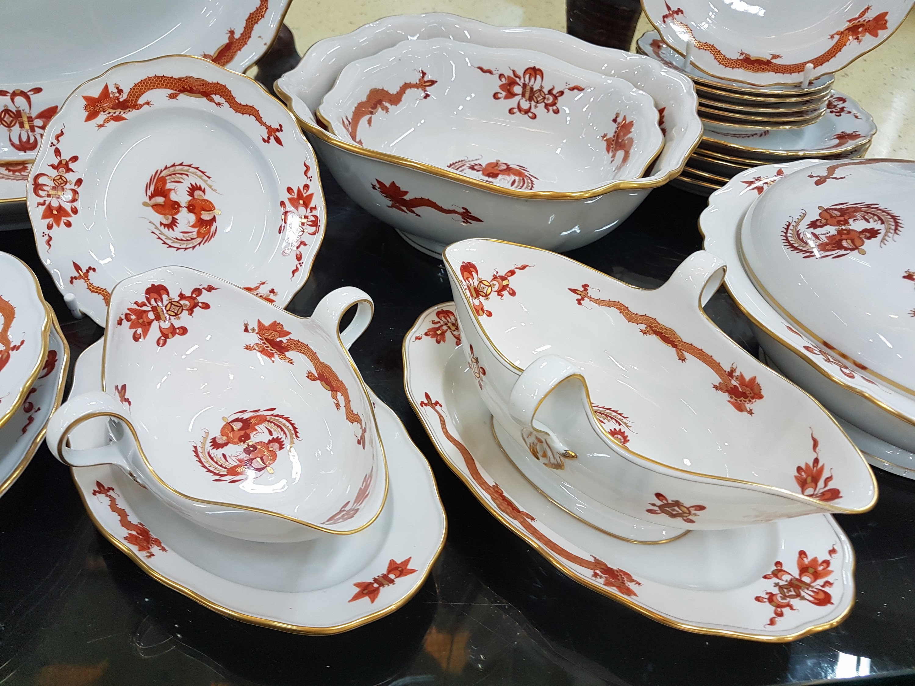 Detail g: Speiseservice, Meissen, 20. Jh., 1. Wahl, Dekor roter Hofdrache goldschattiert, 11 flache Teller, 3 tiefe Teller (davon einer 2. Wahl), 6 ...