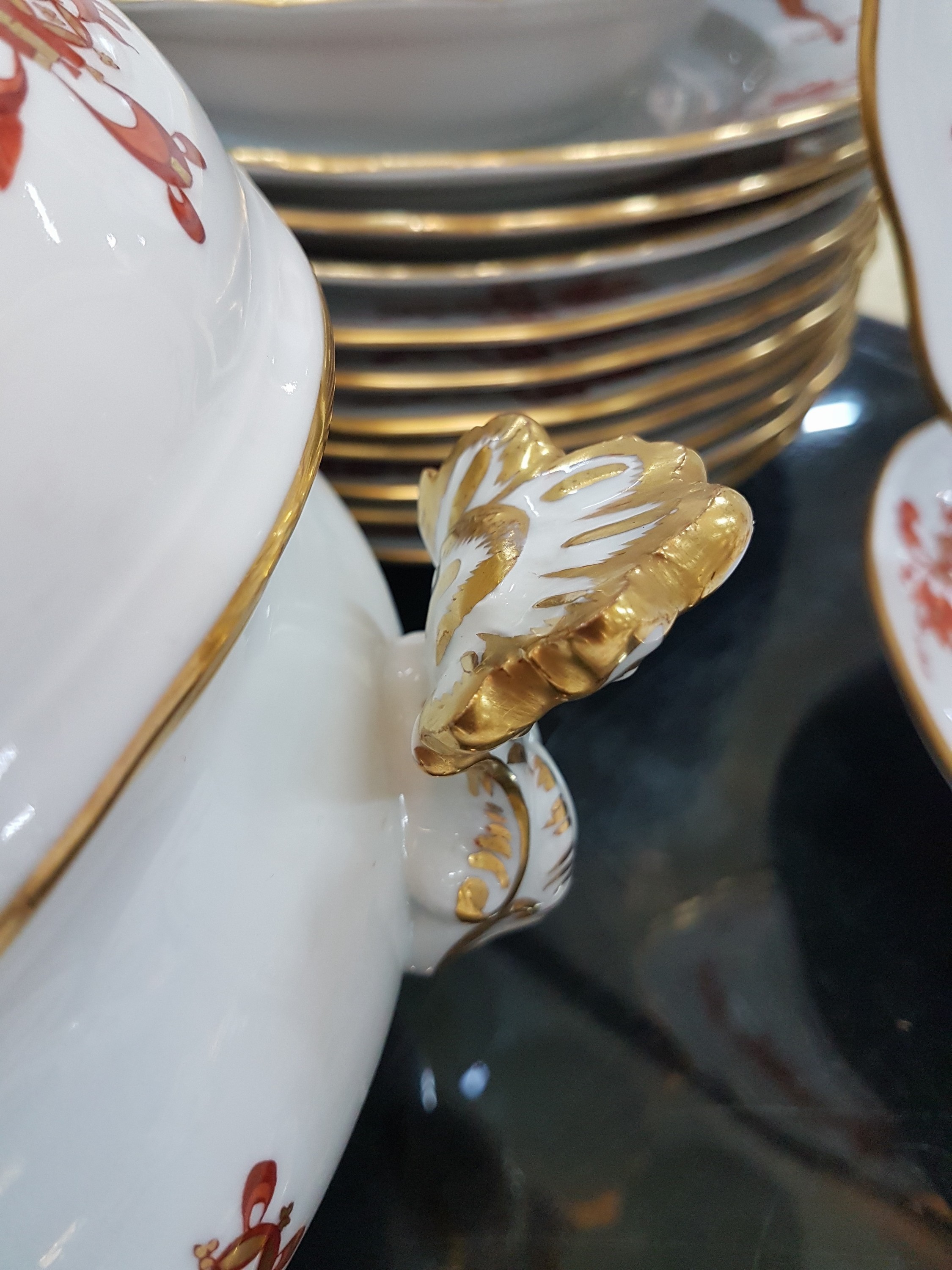 Detail j: Speiseservice, Meissen, 20. Jh., 1. Wahl, Dekor roter Hofdrache goldschattiert, 11 flache Teller, 3 tiefe Teller (davon einer 2. Wahl), 6 ...