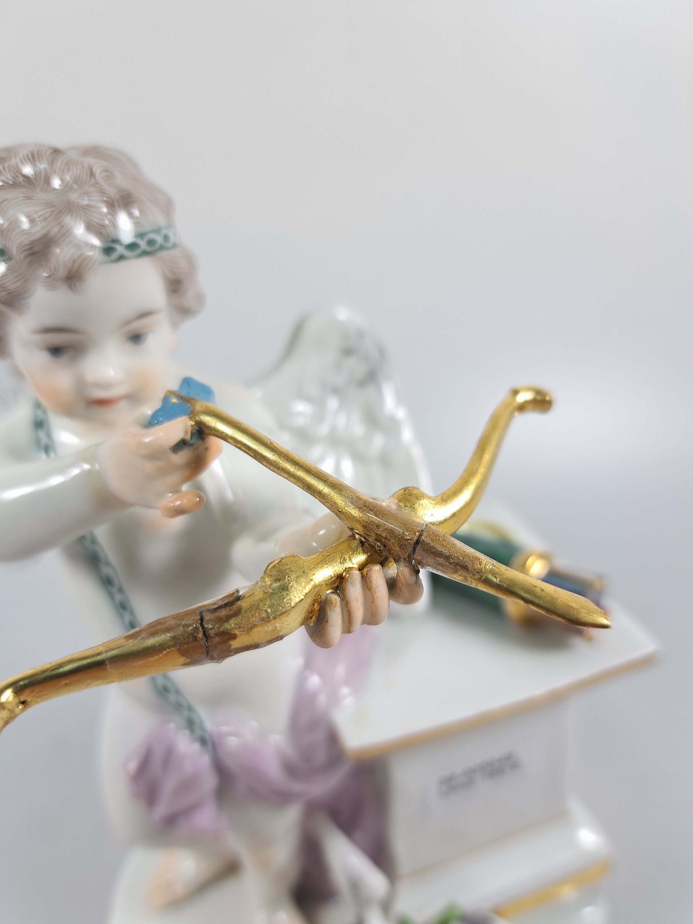 Detail c: Porzellanfigur, Meissen, um 1890, Amor mit Pfeil und Bogen, Entwurf M.V. Acier, Porzellan, bemalt, Goldstaffage, mehrfach geklebt bzw. restauriert, ...