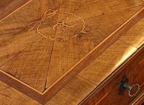 Detail c: Deckelschatulle, um 1800, Nußbaum- und Mahagonifurnier, im Deckel intarsiertes Monogramm TC, innen mit Tapete ausgeschlagen und mit drei kleinen ...