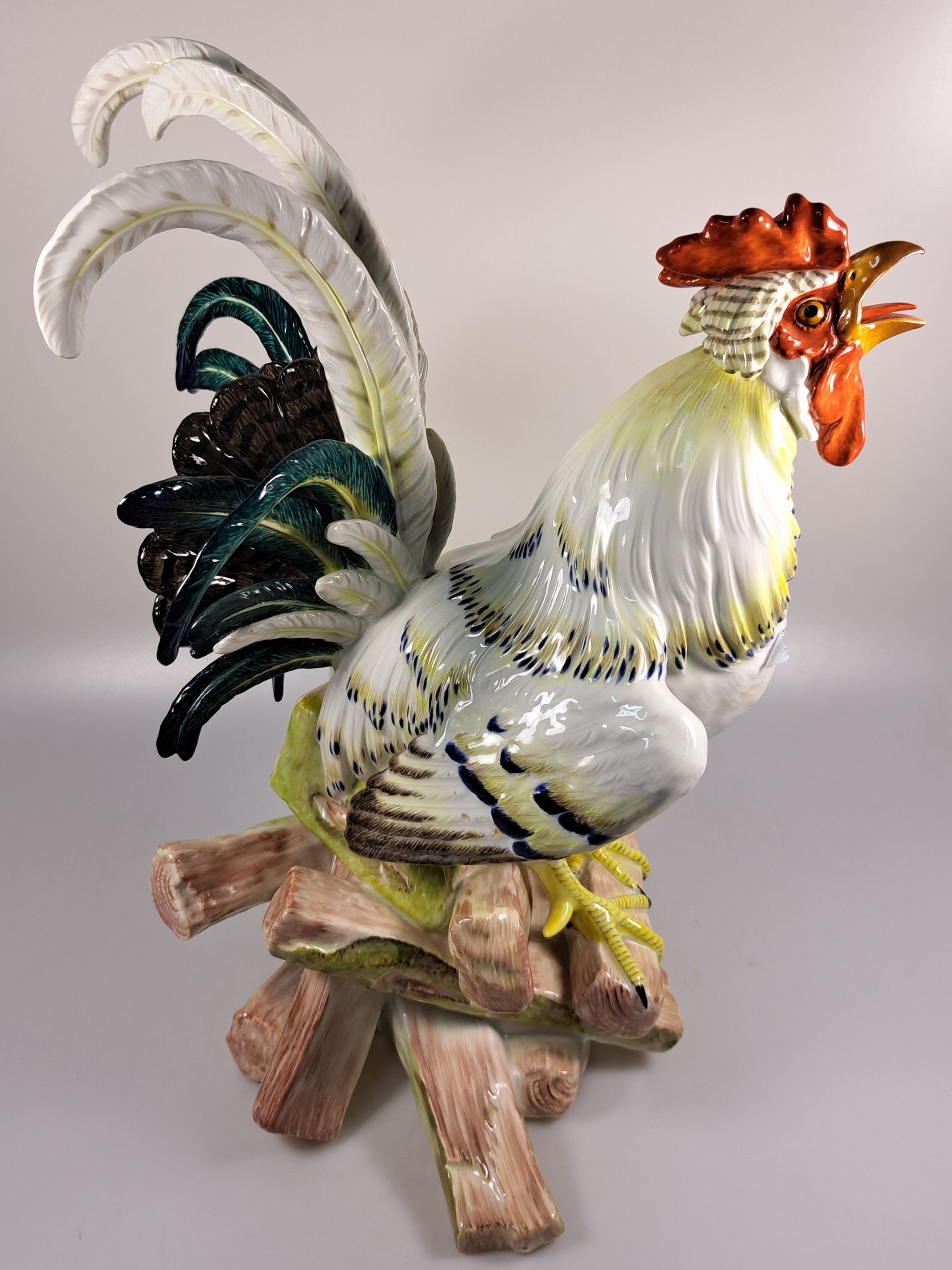 Detail c: Große Porzellanfigur, Meissen, um 1900, Entwurf J.J. Kaendler 1741, Haushahn auf Holzstoss, reich bunt bemalt, eine Schwanzfeder fehlt, H. ca. 40cm, ...