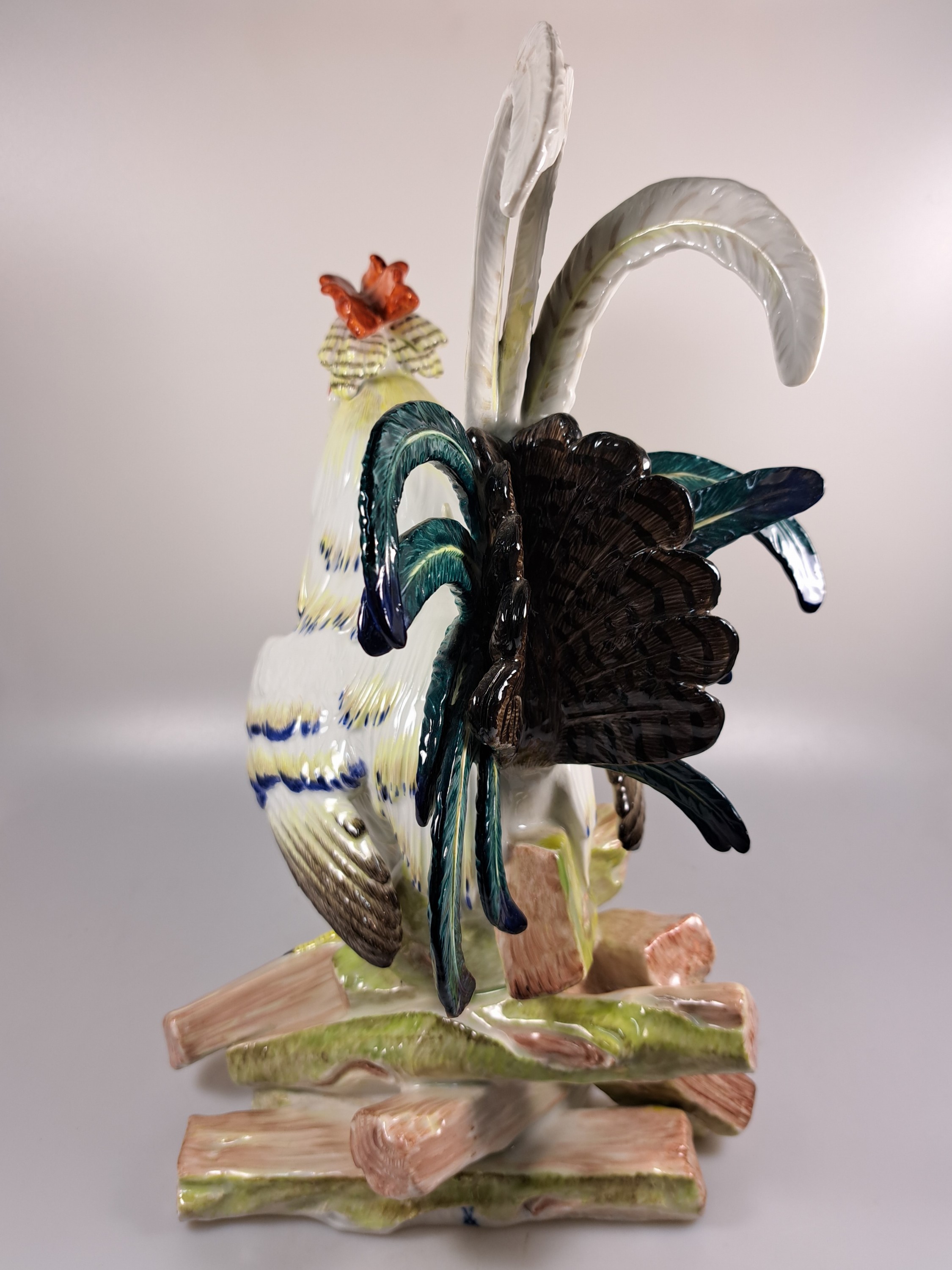 Detail e: Große Porzellanfigur, Meissen, um 1900, Entwurf J.J. Kaendler 1741, Haushahn auf Holzstoss, reich bunt bemalt, eine Schwanzfeder fehlt, H. ca. 40cm, ...