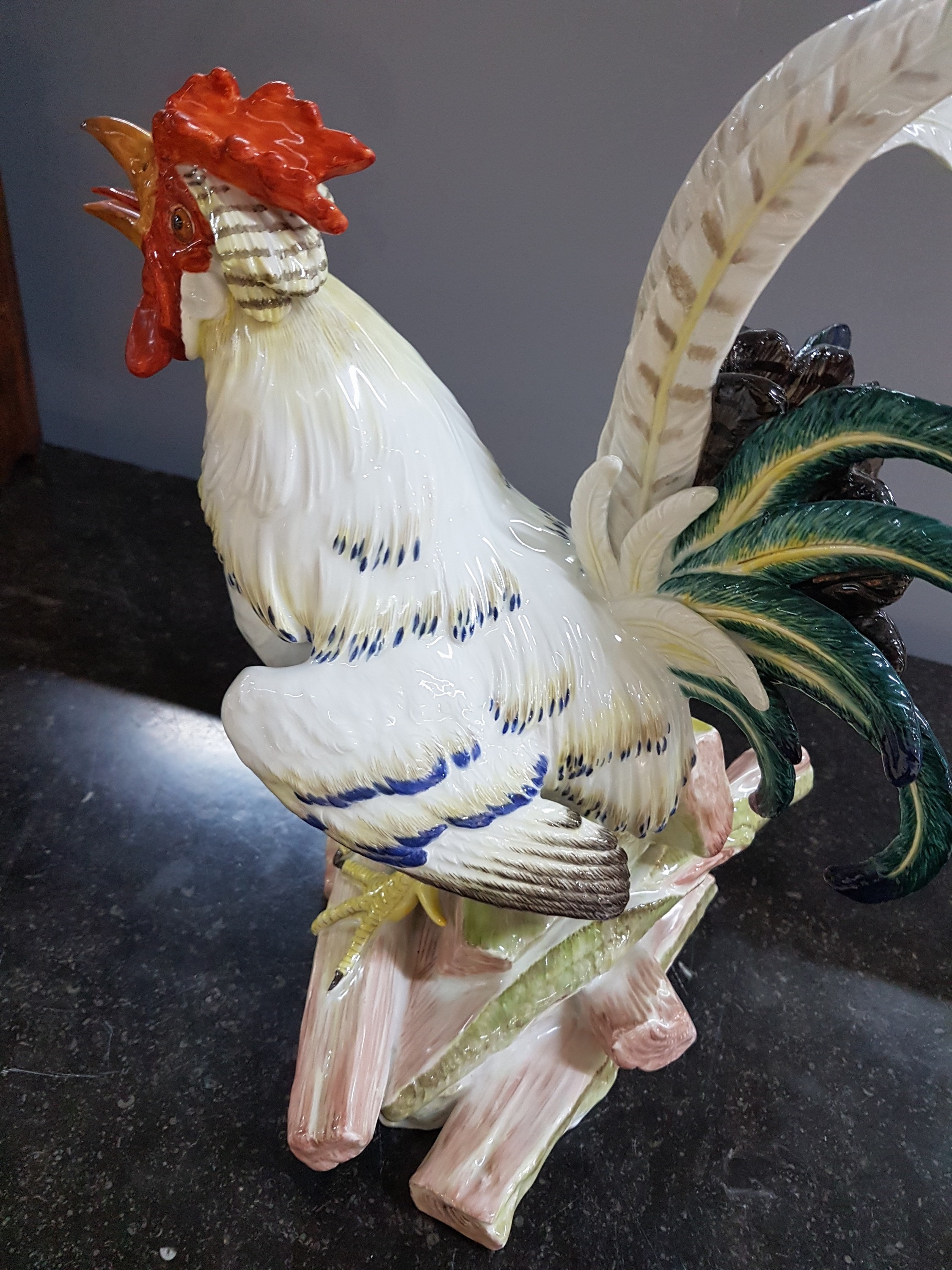 Detail m: Große Porzellanfigur, Meissen, um 1900, Entwurf J.J. Kaendler 1741, Haushahn auf Holzstoss, reich bunt bemalt, eine Schwanzfeder fehlt, H. ca. 40cm, ...