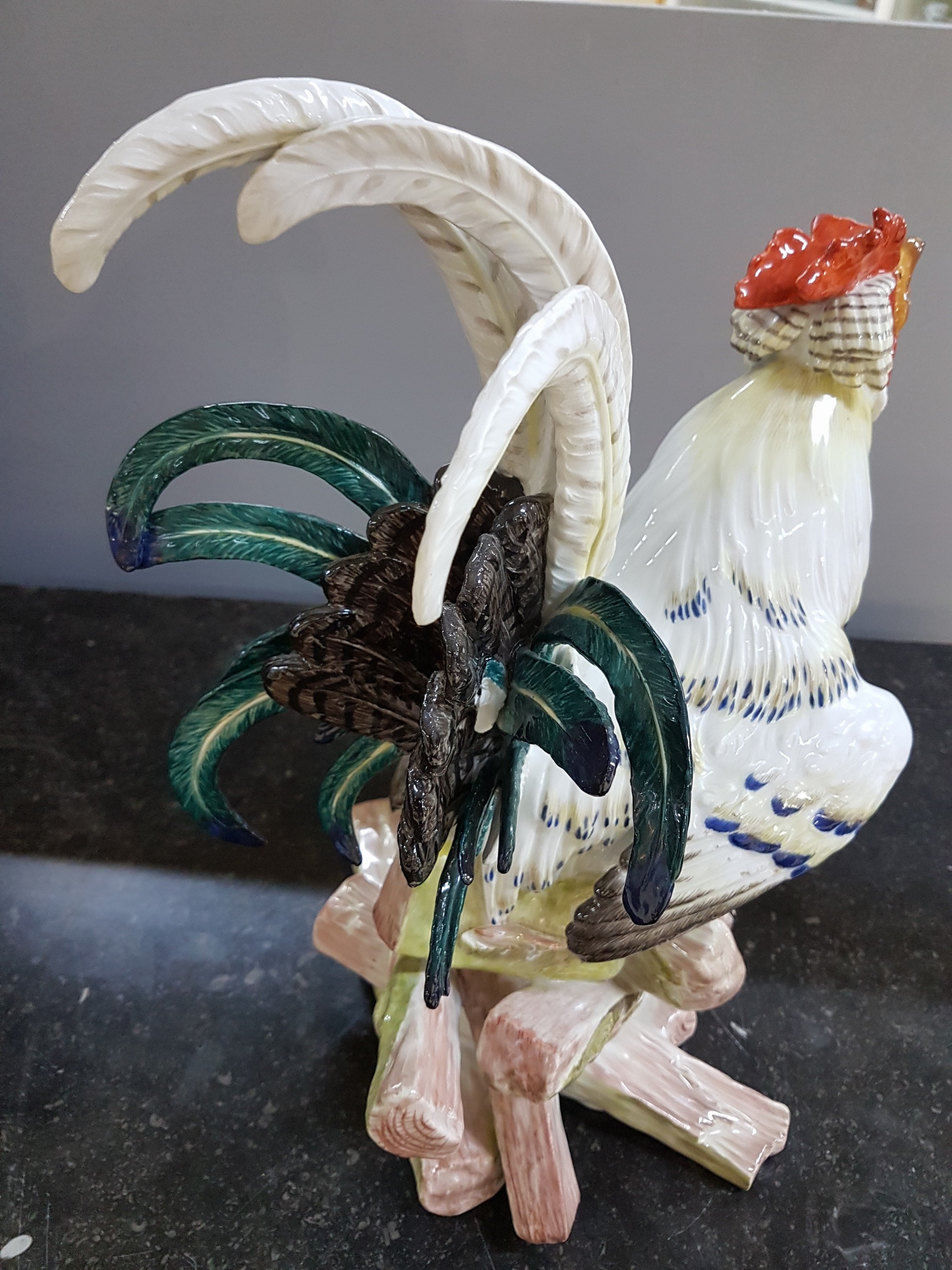Detail p: Große Porzellanfigur, Meissen, um 1900, Entwurf J.J. Kaendler 1741, Haushahn auf Holzstoss, reich bunt bemalt, eine Schwanzfeder fehlt, H. ca. 40cm, ...