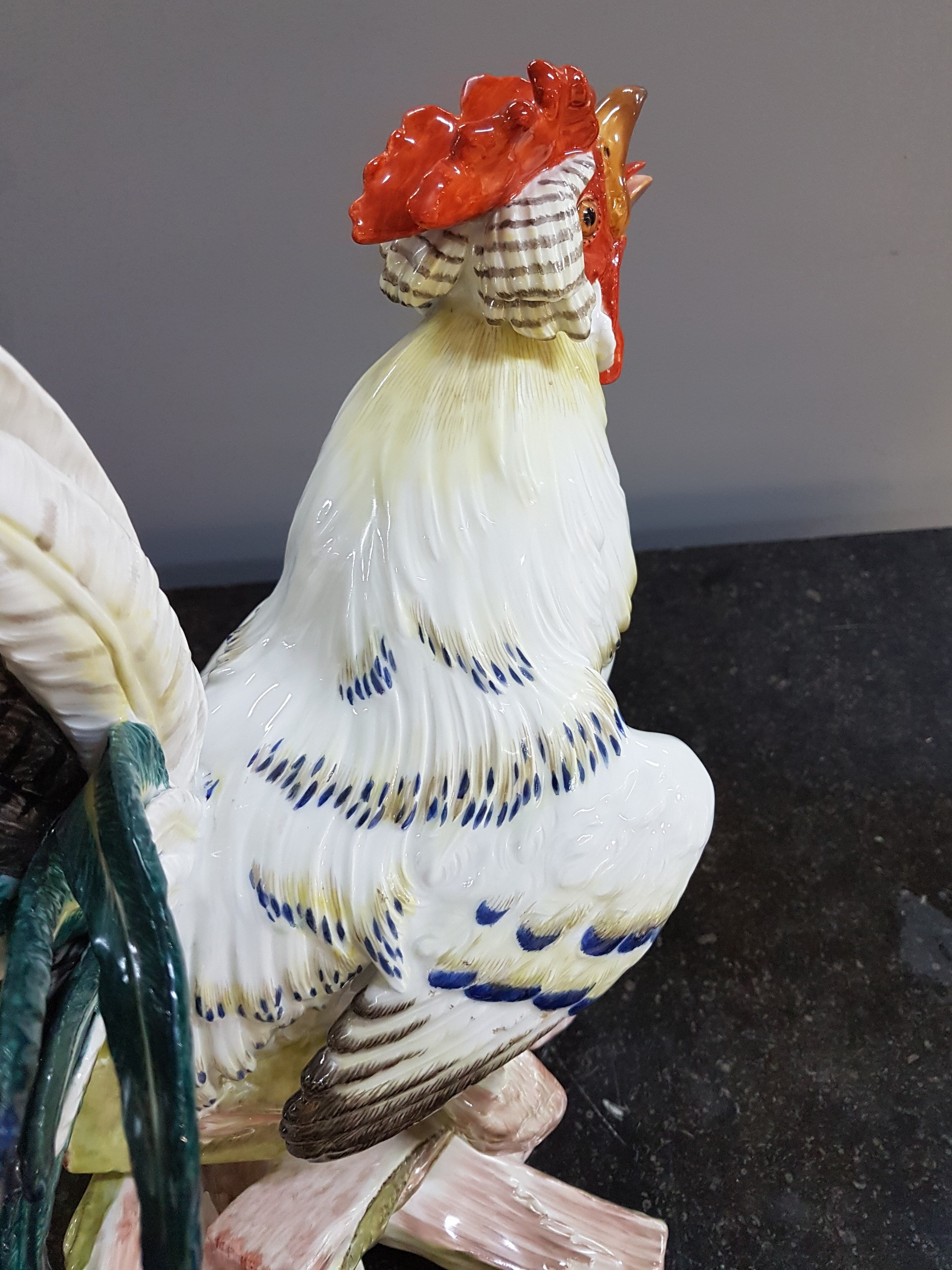 Detail q: Große Porzellanfigur, Meissen, um 1900, Entwurf J.J. Kaendler 1741, Haushahn auf Holzstoss, reich bunt bemalt, eine Schwanzfeder fehlt, H. ca. 40cm, ...