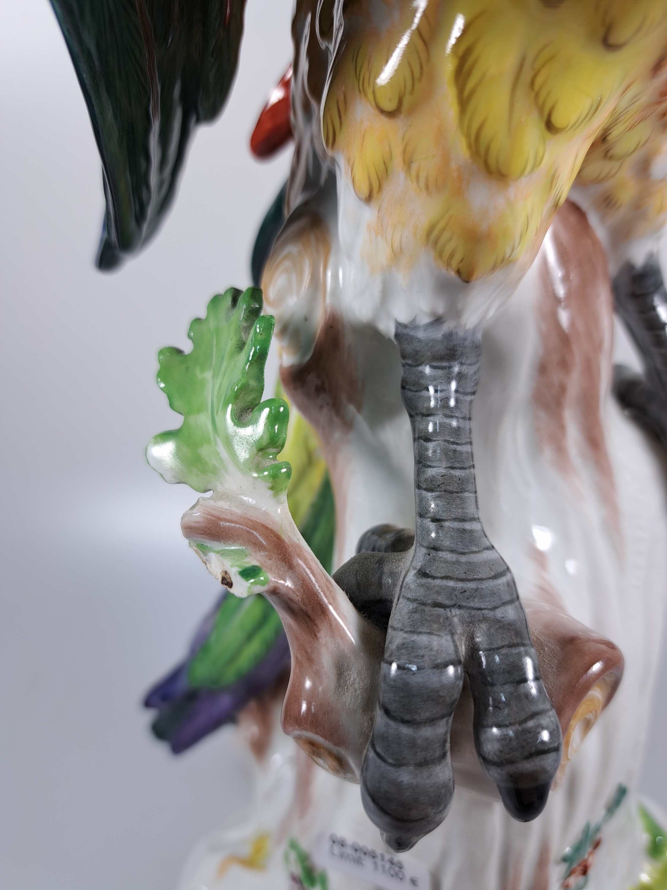 Detail i: Große Porzellanfigur, Meissen, um 1890, Papagei auf Baumstumpf, nach einem Entwurf von J.J. Kändler, fein bunt bemalt, Modellnr. A43b, Brandriss am ...