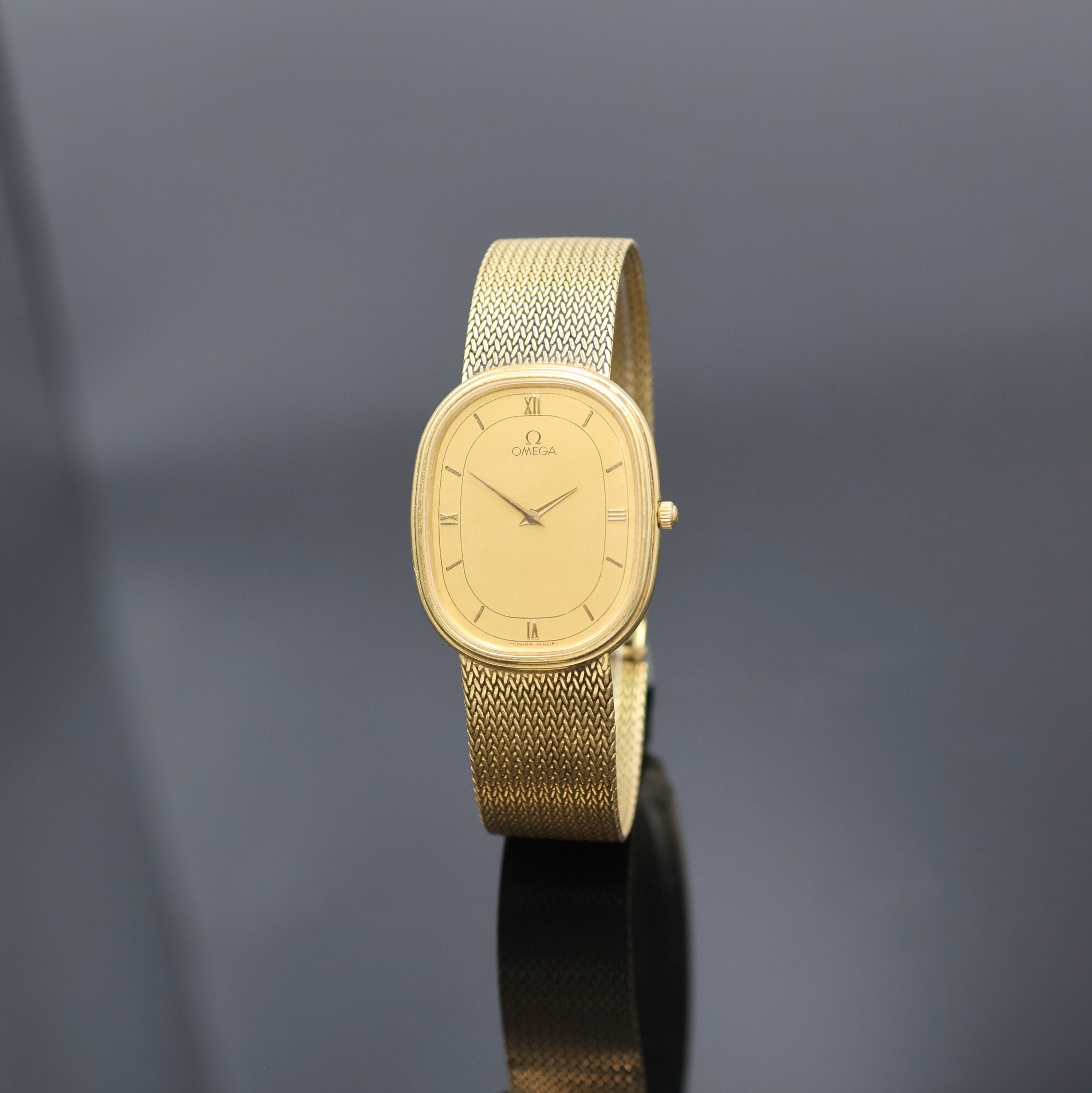 OMEGA Herrenarmbanduhr in GG 750/000 Referenz 395.995.BA, quarz, Schweiz 1980er Jahre, ovales, 2-teil. Geh. inkl. Milanaiseband, Boden 4-fach ...