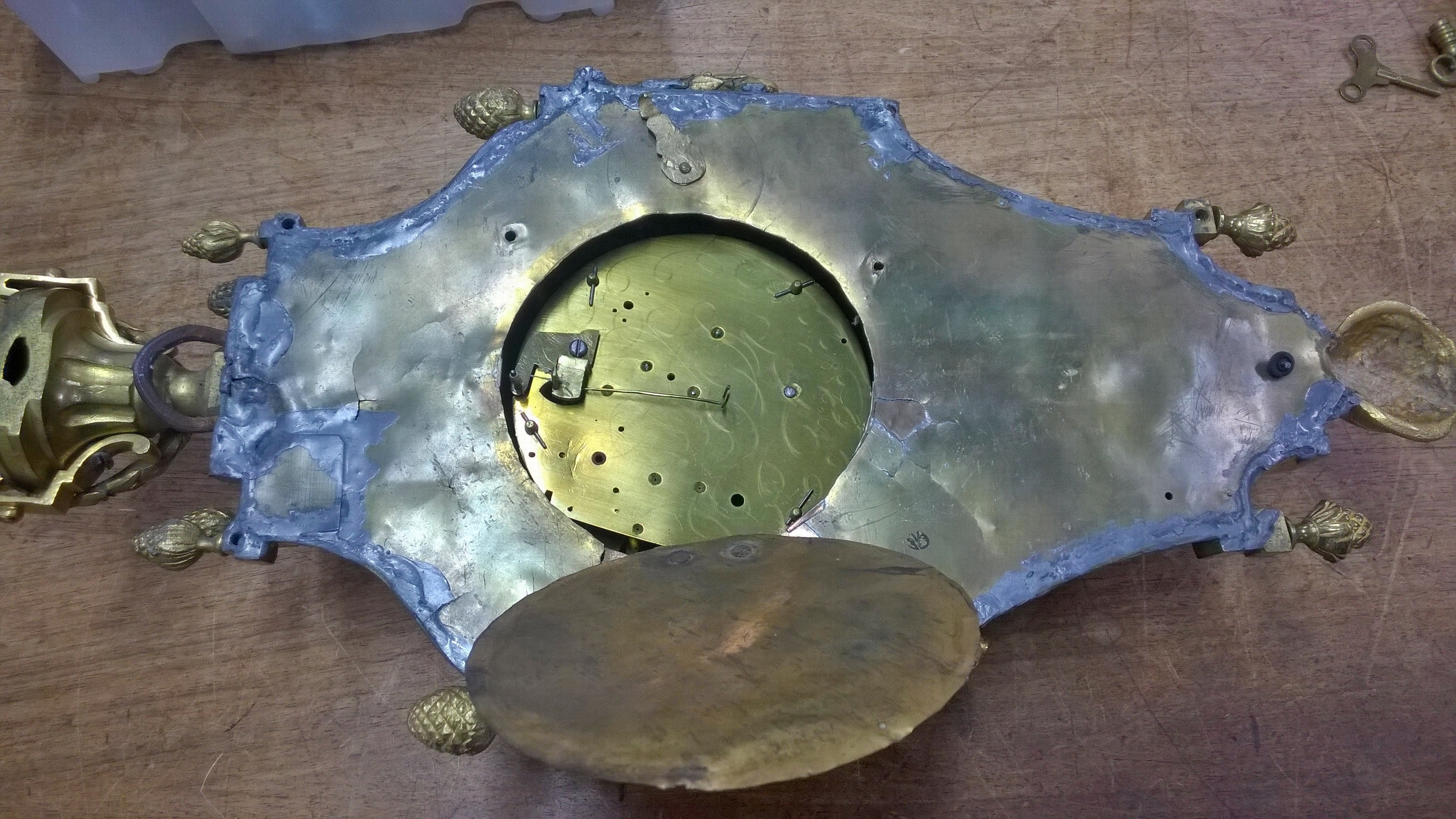 Detail a: Kartelluhr, Jean Biesta (1754-1789), Paris, Bronzegehäuse vergoldet, stark berieben, Rückwand unsachgemäß gelötet, stark gewölbter Glasdeckel, ...