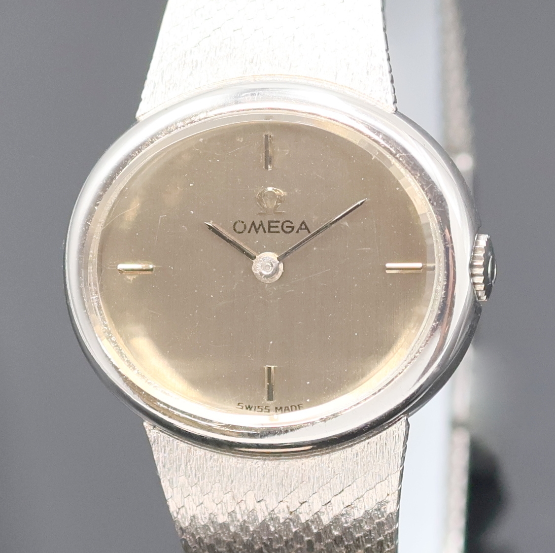 Detail a: OMEGA Damenarmbanduhr in WG 585/000, Schweiz um 1971, Handaufzug, 2-teil. ovales Geh. m. Milanaiseband, Boden aufgedr., orig. Krone seitl. im Geh. ...