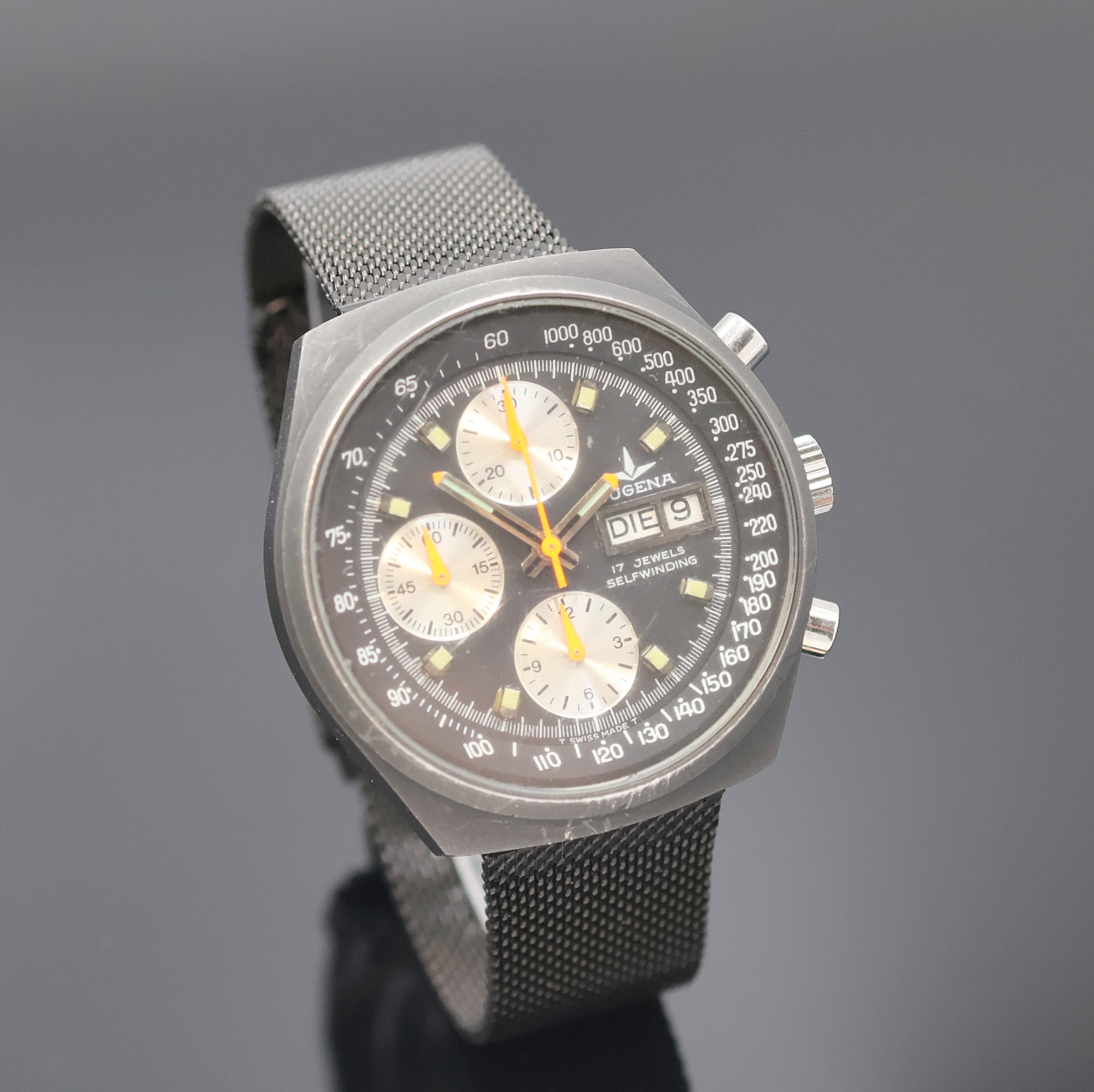 Detail b: DUGENA Herrenchronograph, Schweiz um 1980, Automatik, 2-teil., geschwärztes Edelstahlgeh., verschr. Boden, schwarzes Milanaiseband, schwarzes ...