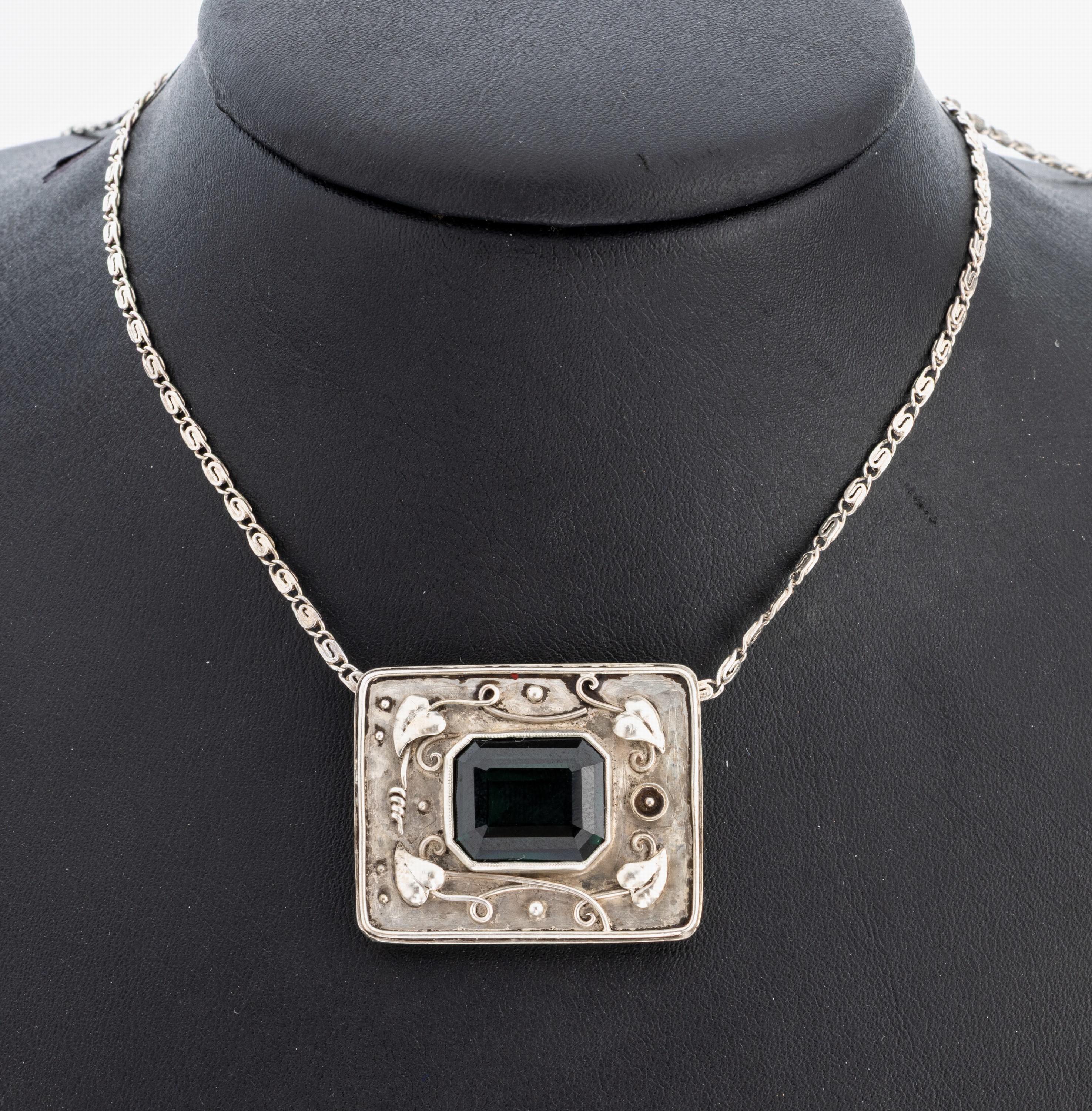 Farbstein-Collier, 1930er Jahre, 835er Silber, Mittelteil, rechteckig, aufgelegte florale Elemente, grüner synth. Spinell im Treppenschliff, L. ca. ...