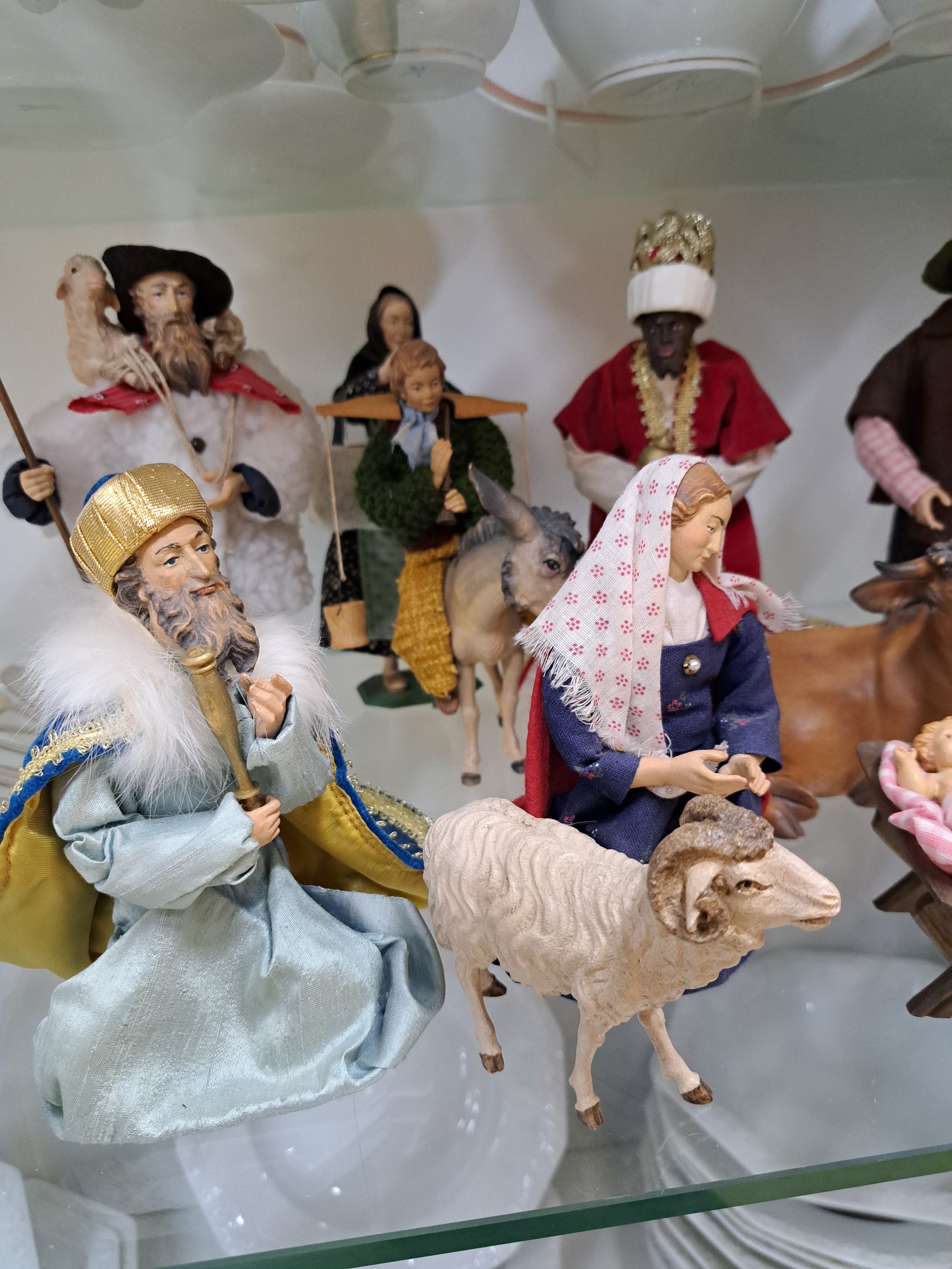 Detail d: Krippenfiguren, 20./21 Jh., Maria, Josef alsHirte, Jesuskind in der Krippe, Ochse, Esel mit Reiter und drei SchafeLamm, Mutter und Tochter, drei Hl. ...