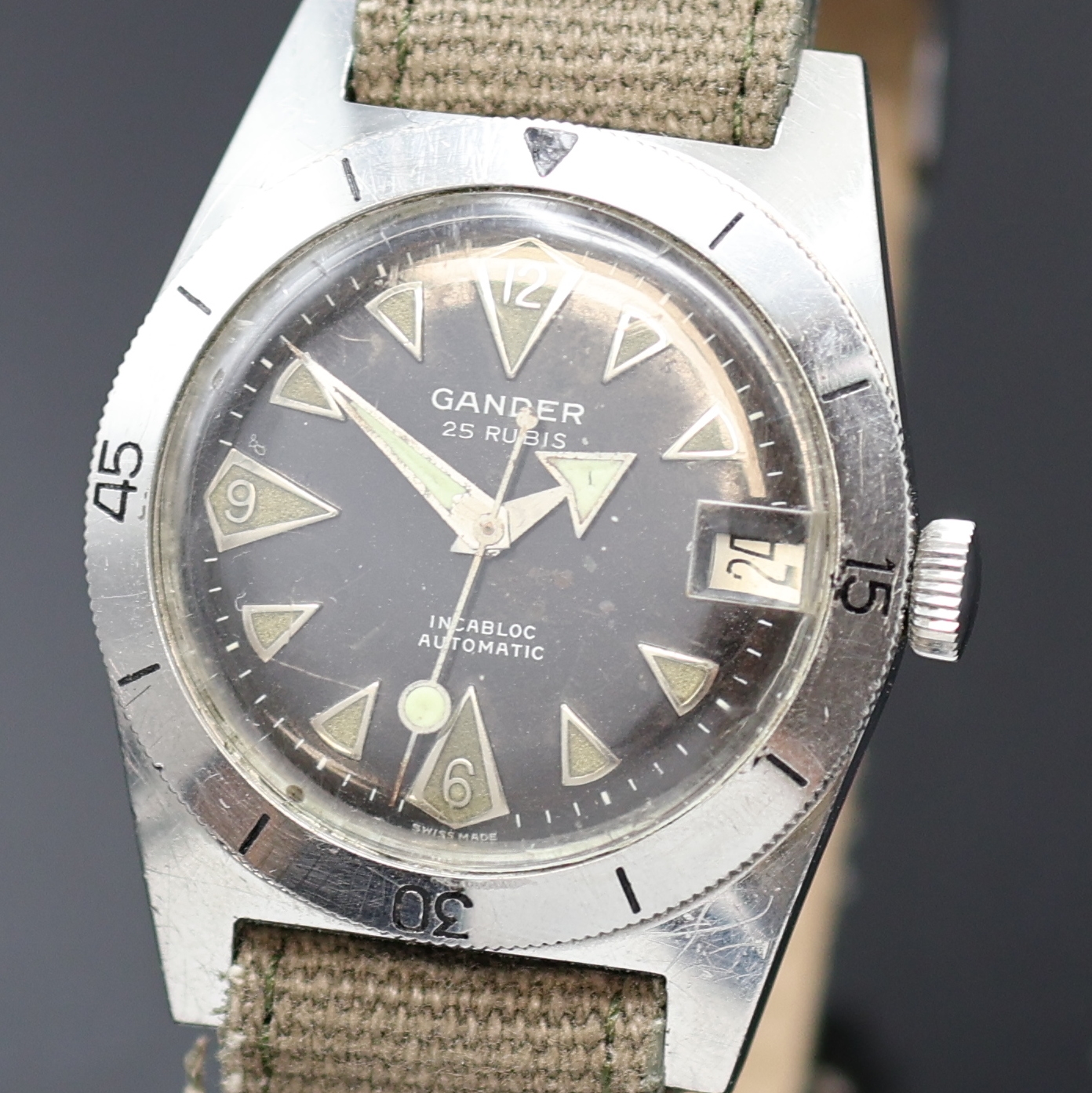 Detail a: GANDER Herrenarmbanduhr in Stahl, Schweiz um 1960, Automatik, Boden verschr., beids. drehb. Lünette m. 60er Teilung, schwarzes Zifferbl. m. ...