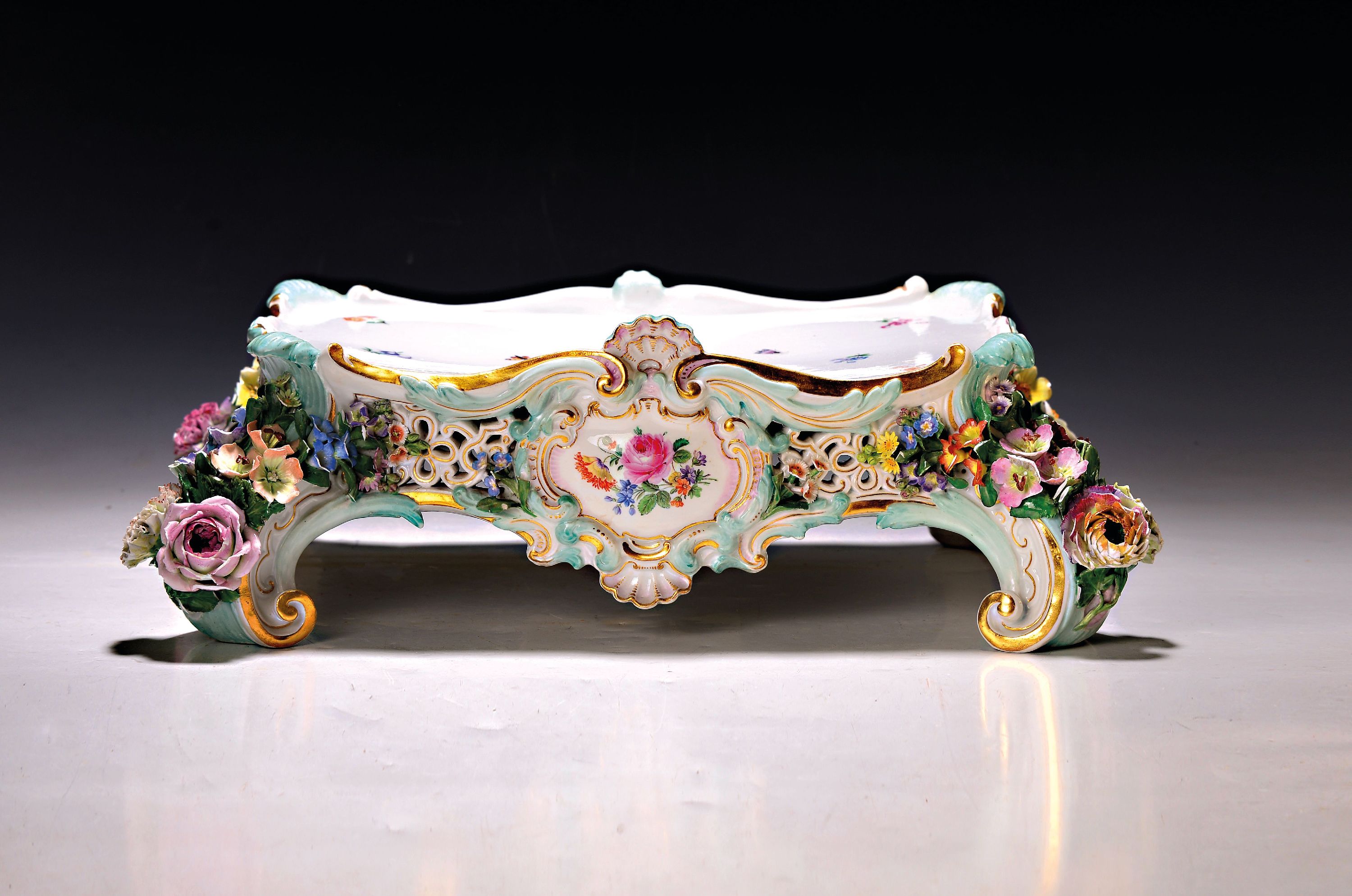 Detail e: Prunkpendule mit Postament, Meissen, um 1880/85, Porzellan, allegorische Darstellung, seitlich mit Durchbrucharbeit, große applizierte Blüten und ...