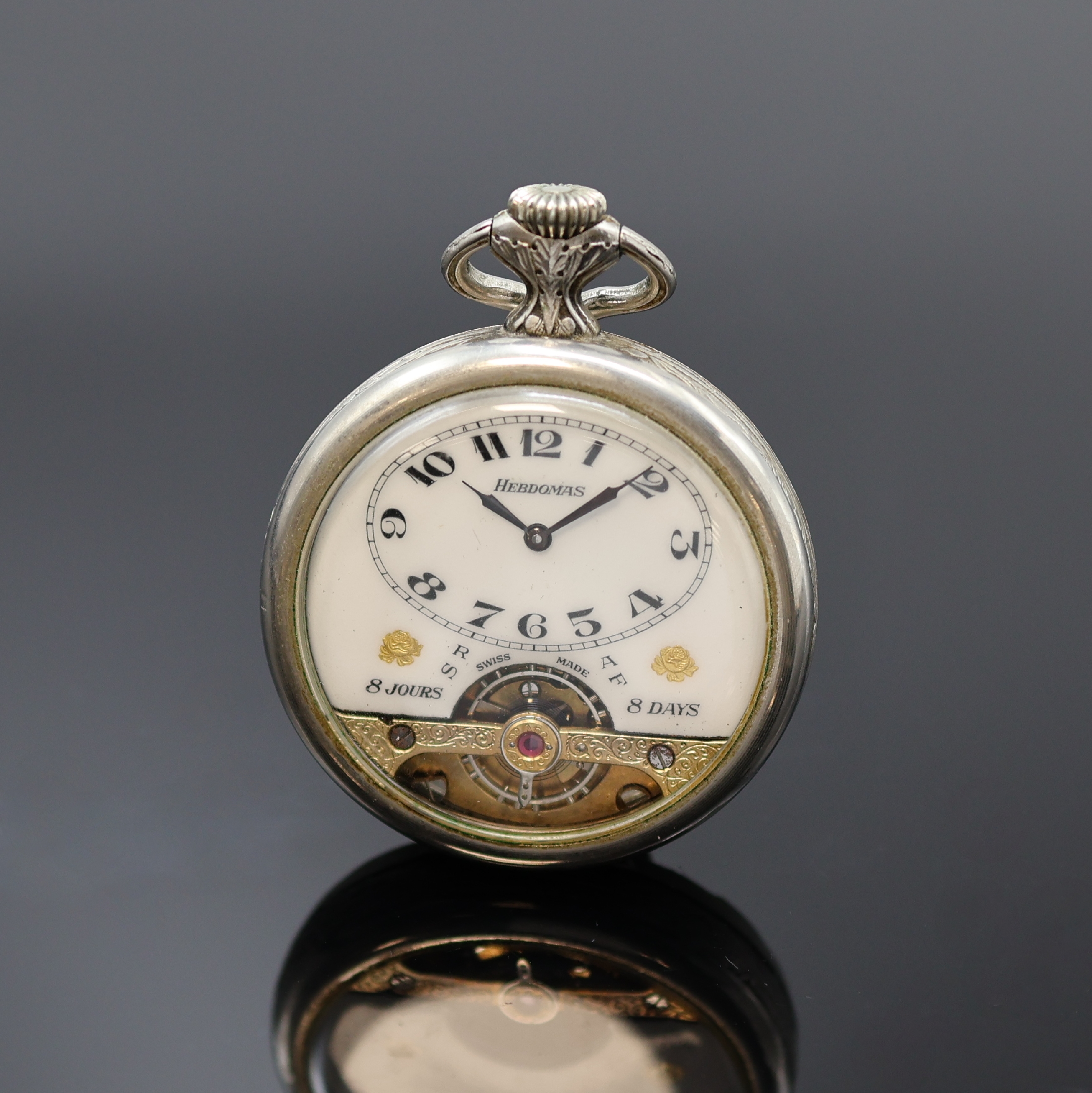 HEBDOMAS offene Herrentaschenuhr mit 8 Tagewerk in Nickel, Schweiz 20. Jhd., Relief-Geh. m. rücks. Jagdszene, 4/5- Emailzifferbl., sichtb. Unruh b. ...