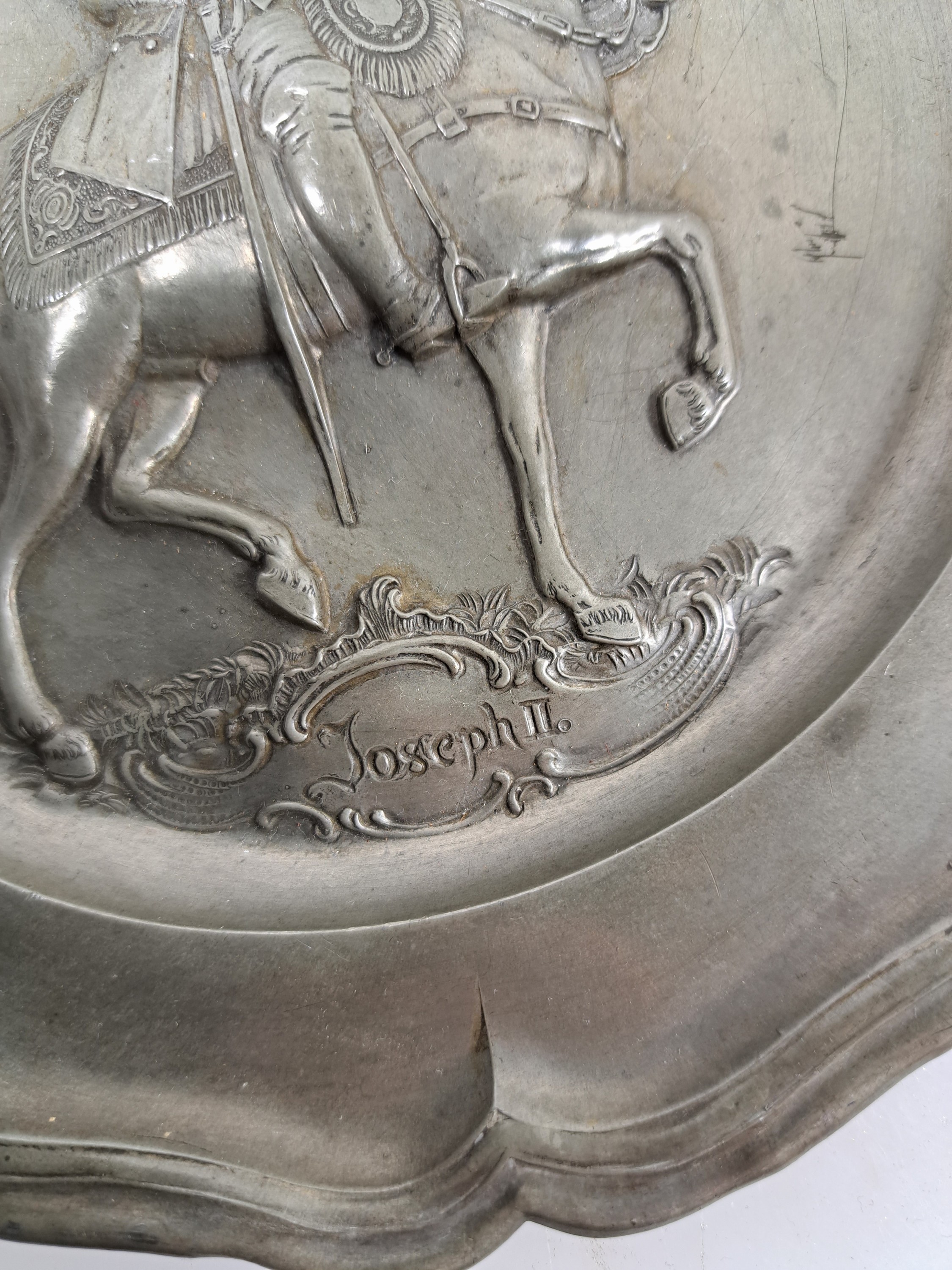 Detail a: Drei Teller, Barock, 18. Jh. Zinn, eine große Probeschale, reich verzierte Doppelhenkel, mit Spruch, L. 34 cm zwei Teller, Reliefs Joseph II und ...