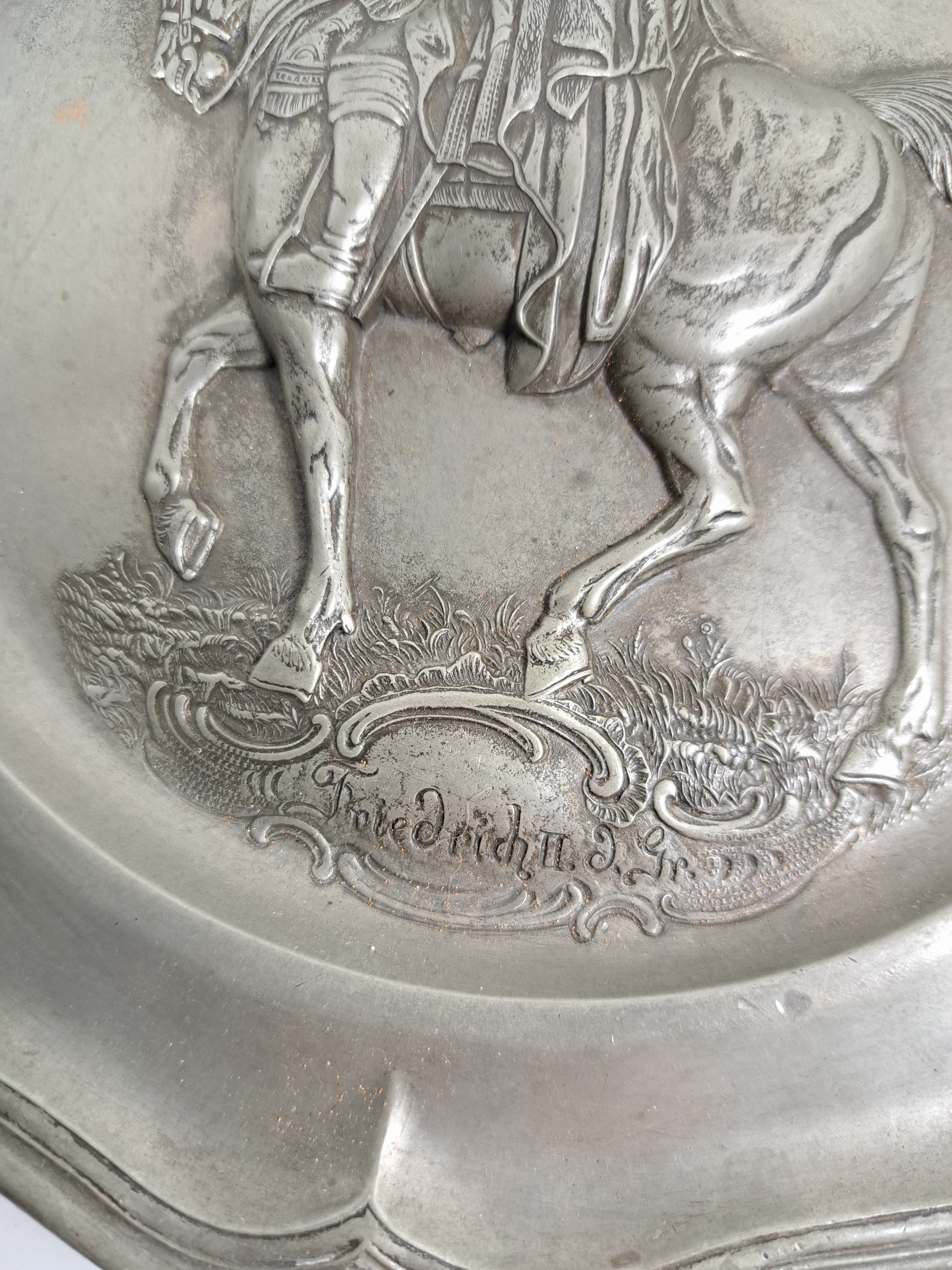 Detail g: Drei Teller, Barock, 18. Jh. Zinn, eine große Probeschale, reich verzierte Doppelhenkel, mit Spruch, L. 34 cm zwei Teller, Reliefs Joseph II und ...