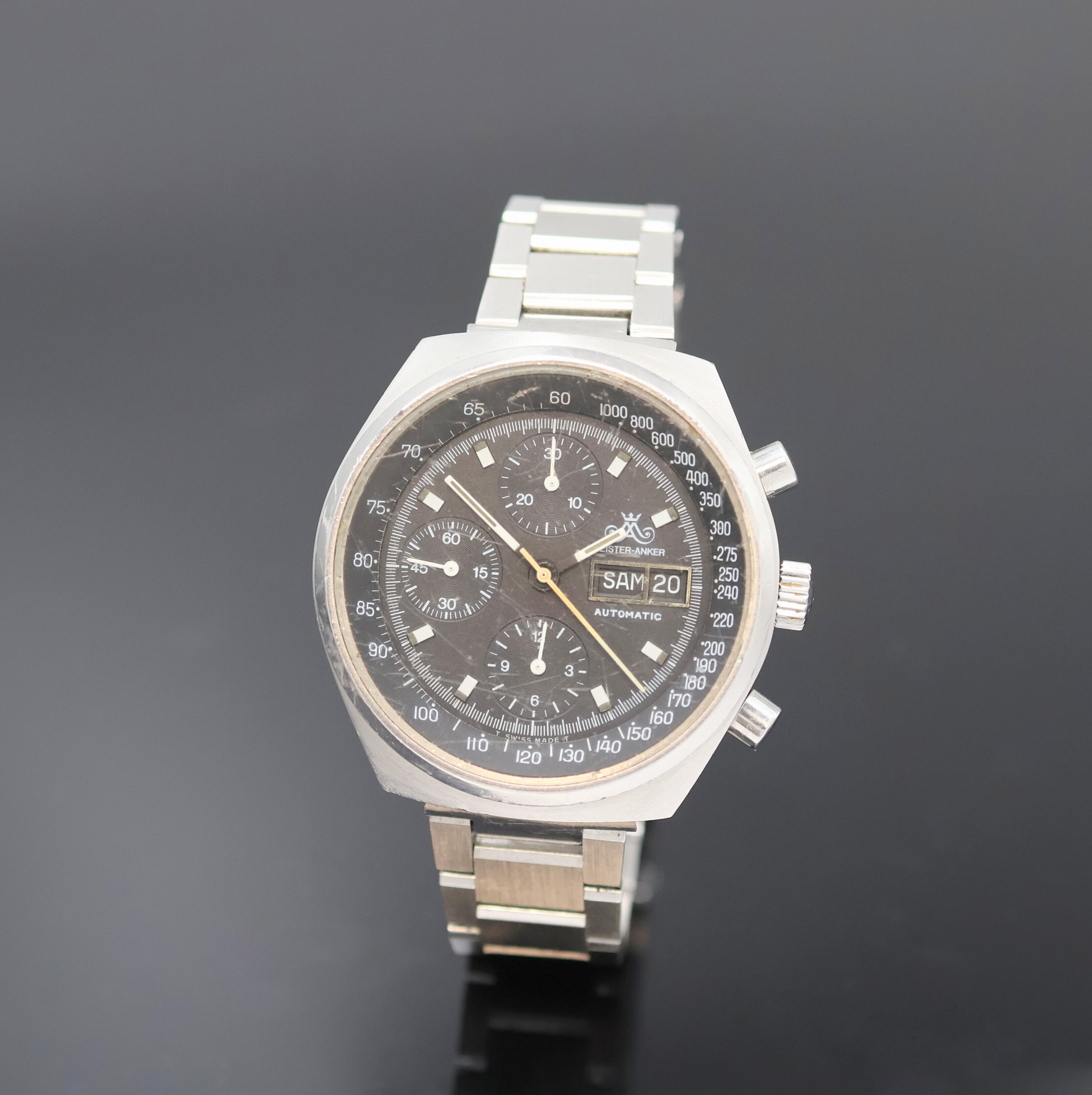 MEISTER-ANKER Armbandchronograph in Stahl, Schweiz um 1980, Automatik, Boden verschr., Dugena Stahlband, schwarzes Zifferbl., Leuchtindizes u. ...