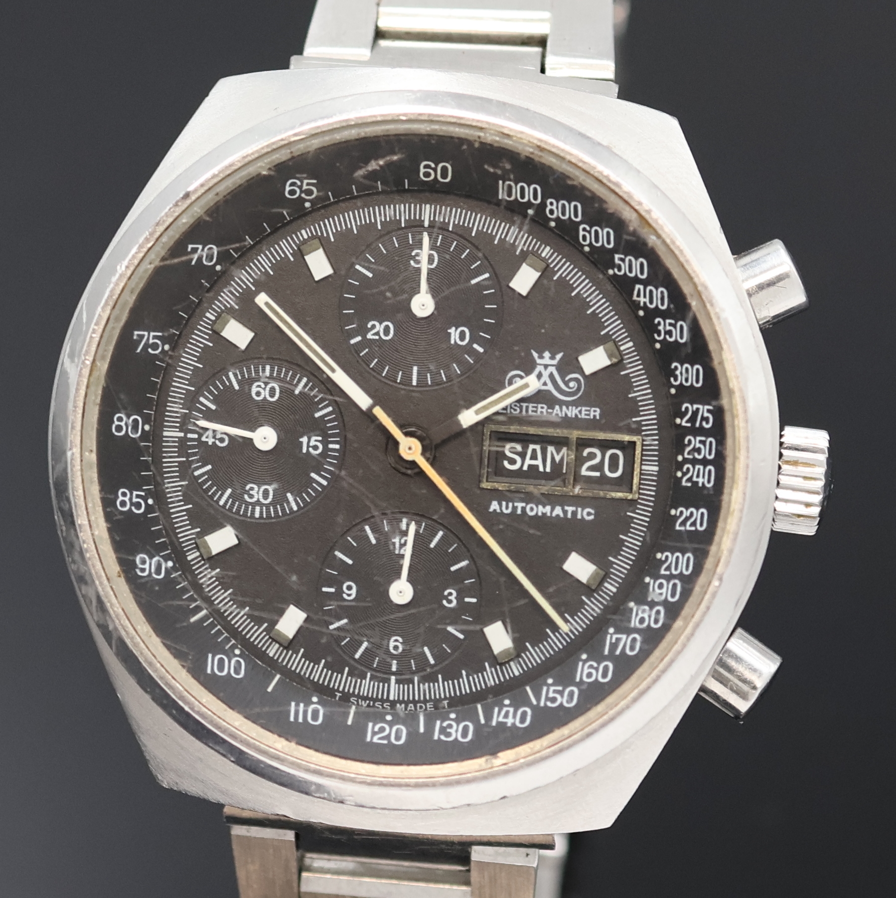 Detail a: MEISTER-ANKER Armbandchronograph in Stahl, Schweiz um 1980, Automatik, Boden verschr., Dugena Stahlband, schwarzes Zifferbl., Leuchtindizes u. ...