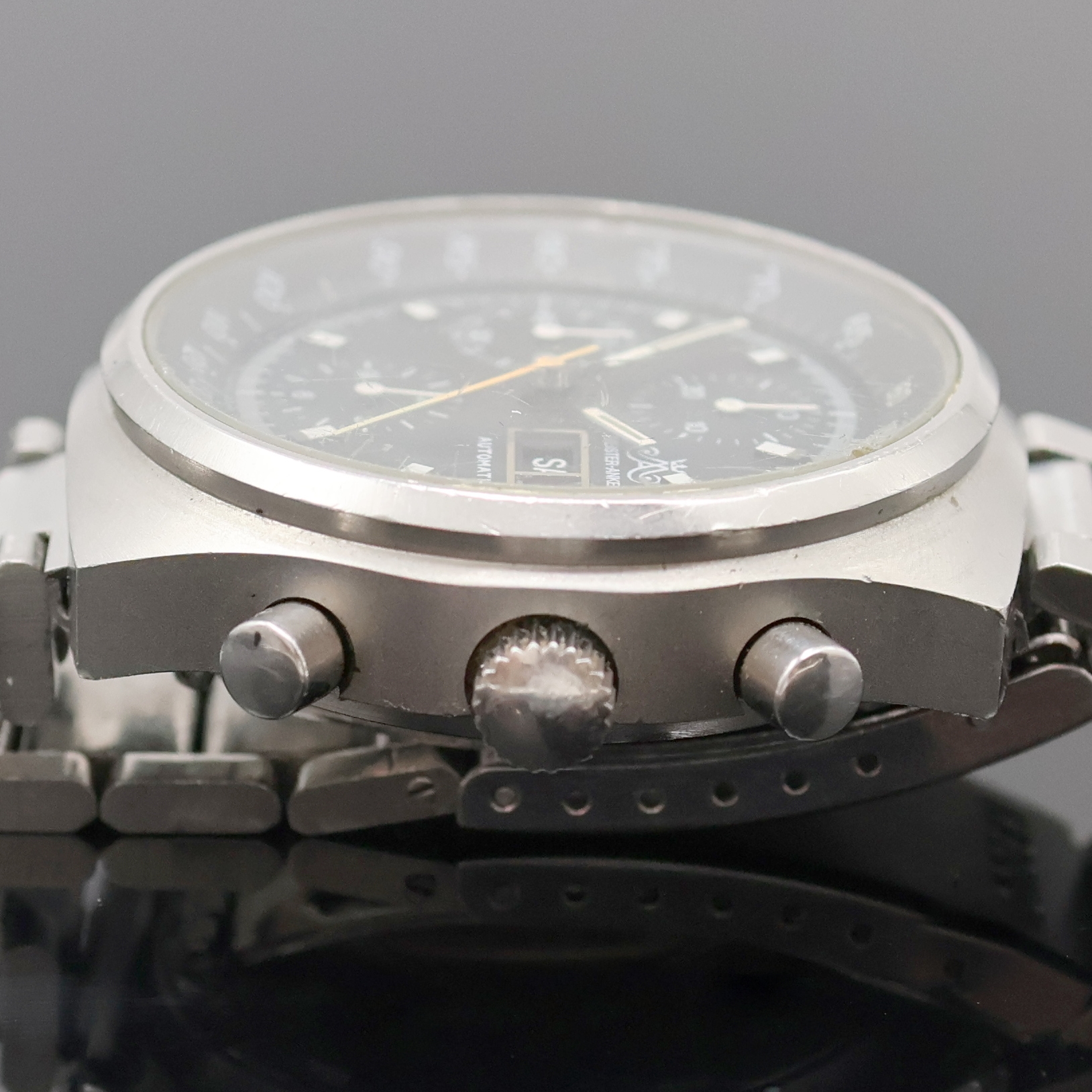 Detail c: MEISTER-ANKER Armbandchronograph in Stahl, Schweiz um 1980, Automatik, Boden verschr., Dugena Stahlband, schwarzes Zifferbl., Leuchtindizes u. ...