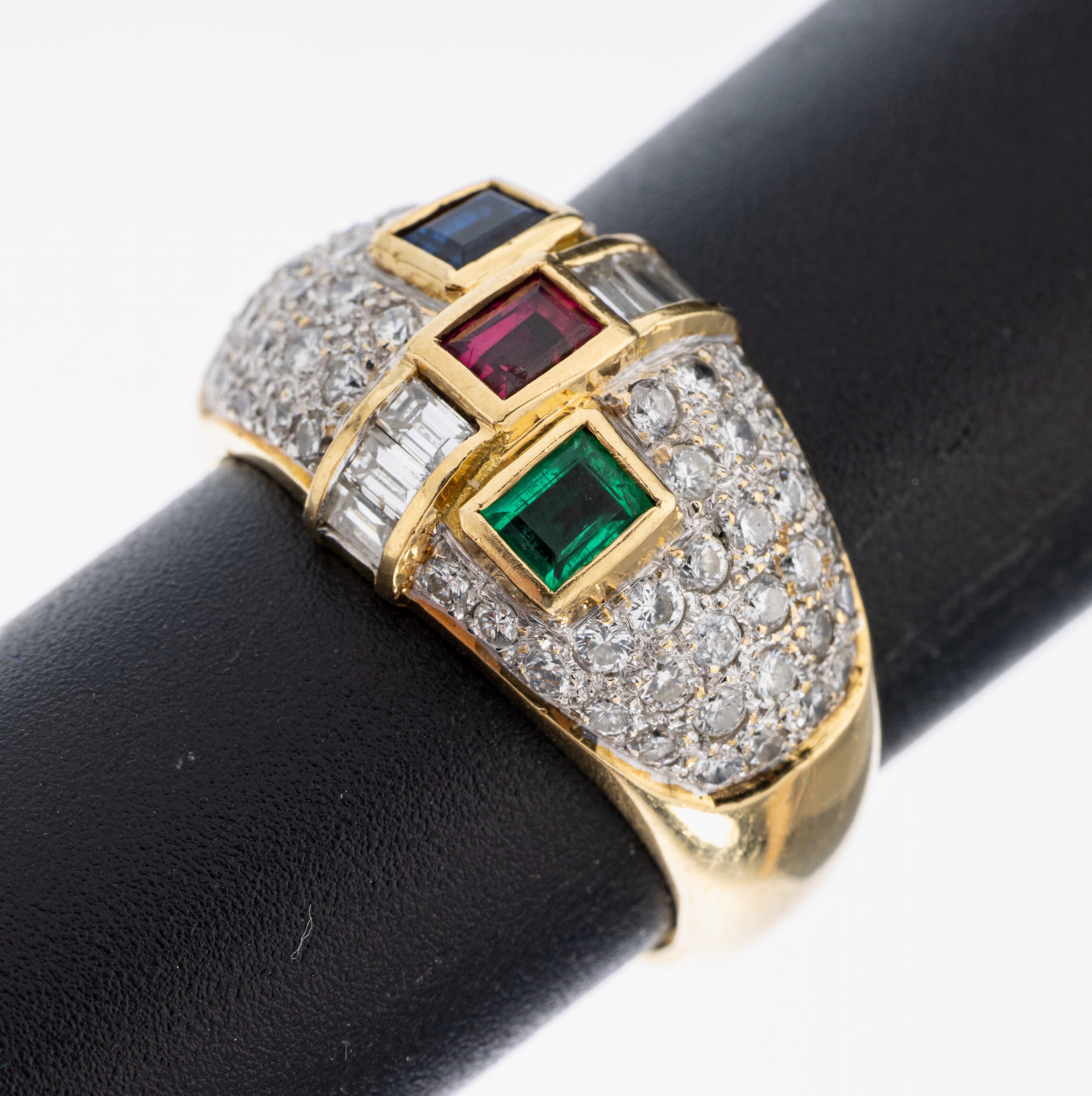 18 kt Gold Farbstein-Diamant-Ring, WG 750/000, je 1 Saphir- Rubin- und Smaragd- Baguette von sehr schöner Farbe zus. ca. 0.60 ct, 6 ...