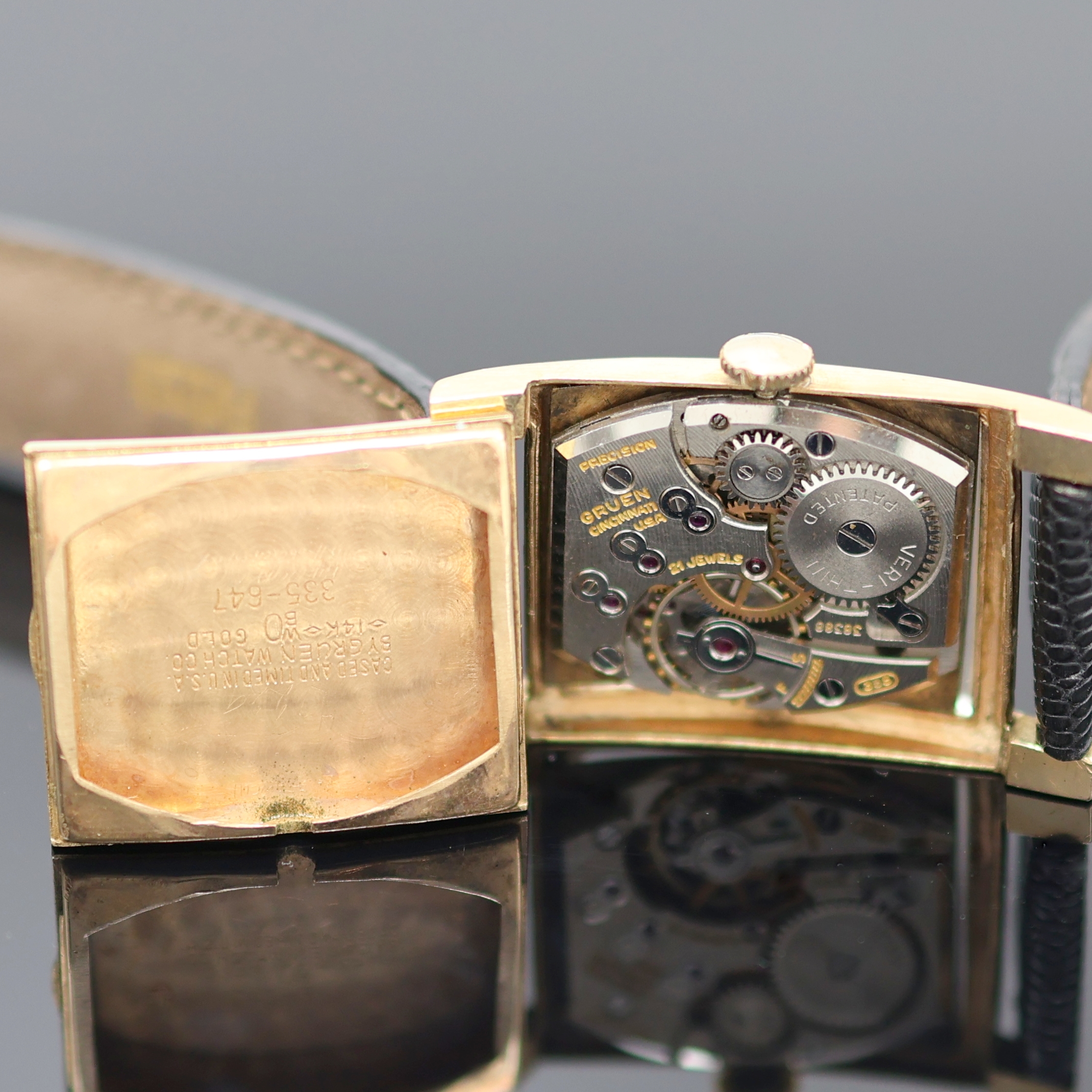 Detail e: GRUEN Precision Armbanduhr in GG 585/000, USA um 1945, Handaufzug, Boden m. Monogramm aufgedr., schwarzes Zifferbl. m. arab. Zahlen u. gold. ...